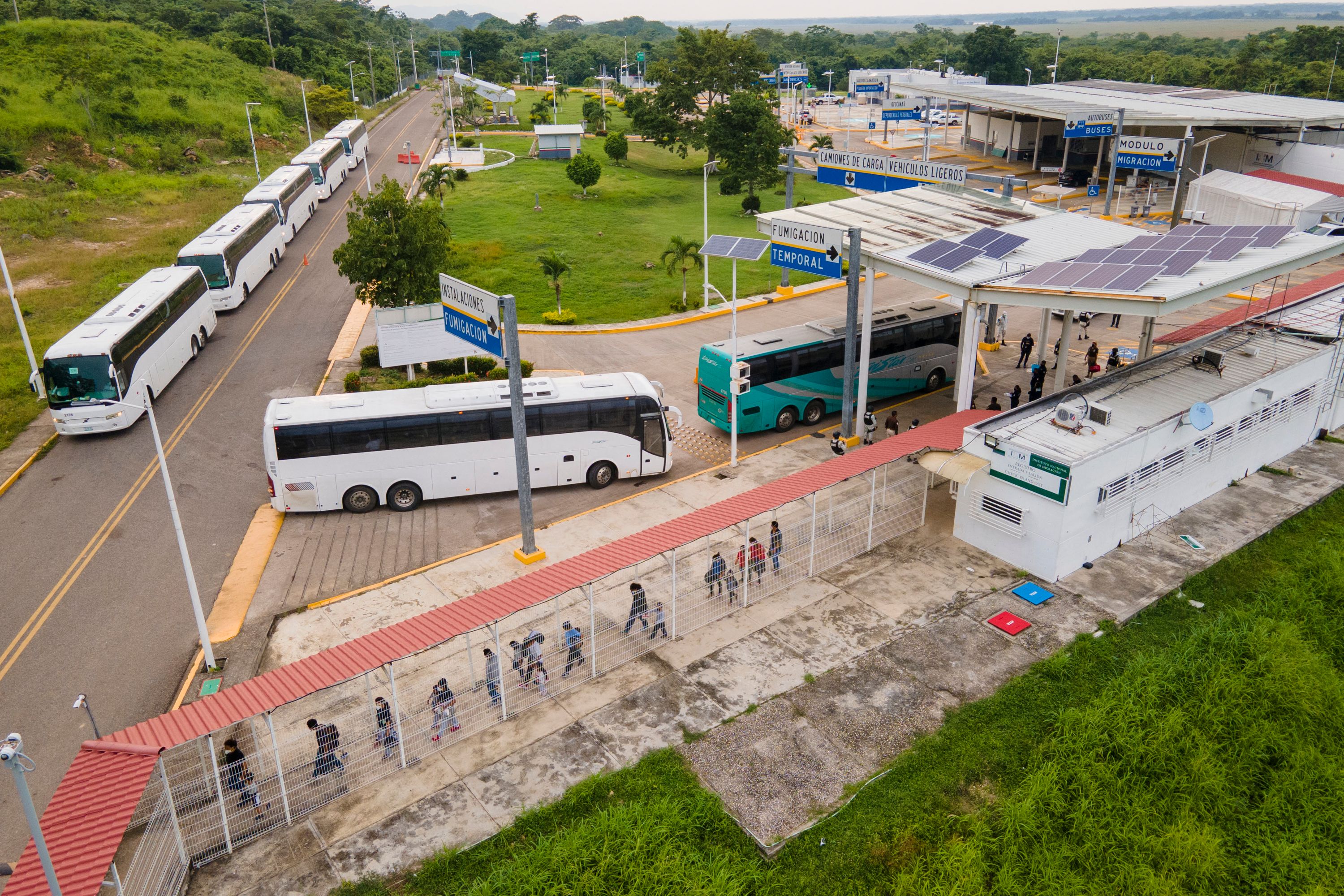 Buses con migrantes guatemaltecos y centroamericanos cruzan el paso fronterizo de El Ceibo, en Petén, para ser abandonados a su suerte. (Foto Prensa Libre: AFP)