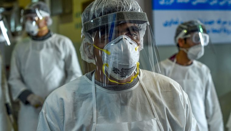 Health services staff members wearing protective gear look on as they wait to check passengers at the Hamid Karzai International Airport in Kabul on February 2, 2020. - Afghan health authorities are establishing isolation wards across the country ahead of a potential influx of coronavirus cases, an official said on February 2, as governments worldwide monitor the disease's spread. (Photo by WAKIL KOHSAR / AFP)