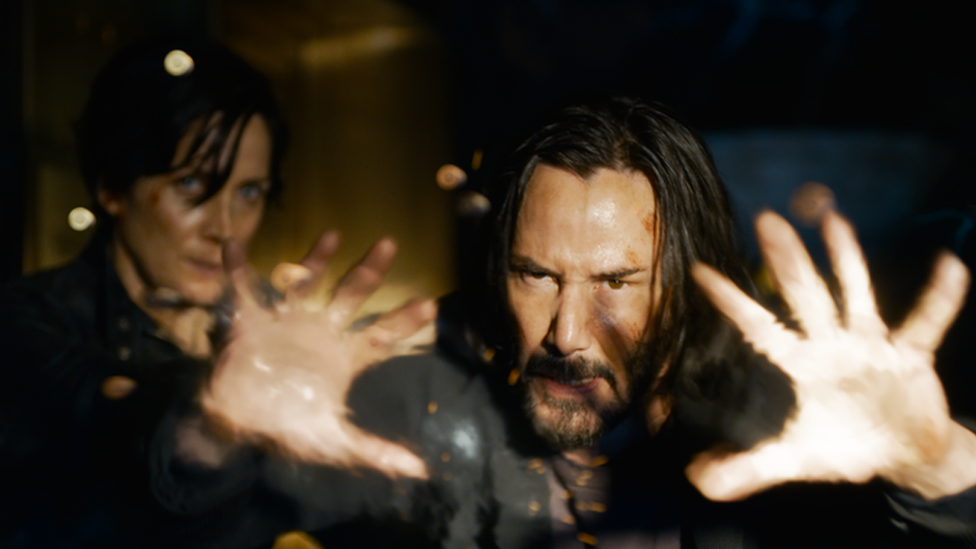 Keanu Reeves interpretando a su personaje Neo junto a Trinity, de Carrie-Anne Moss (izquierda).