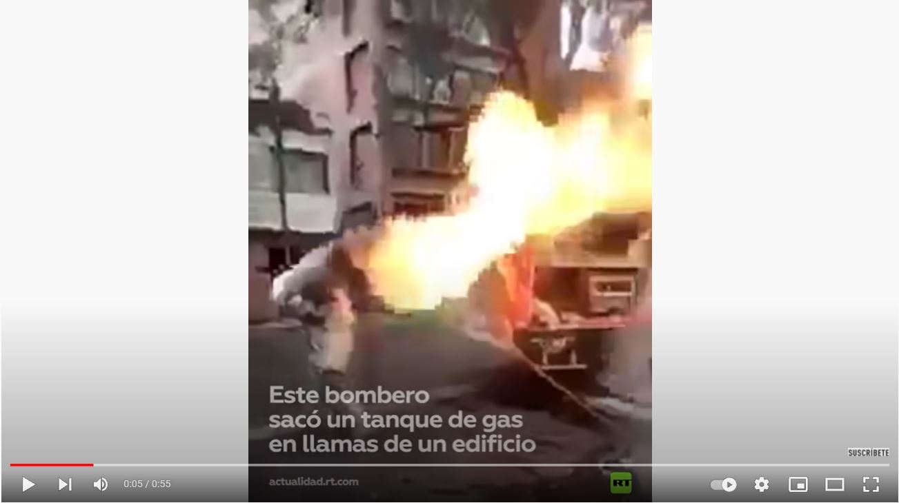 Un bombero carga con un cilindro de gas en llamas en la Ciudad de México para evitar que este explotara. (Foto Prensa Libre: Captura de pantalla)