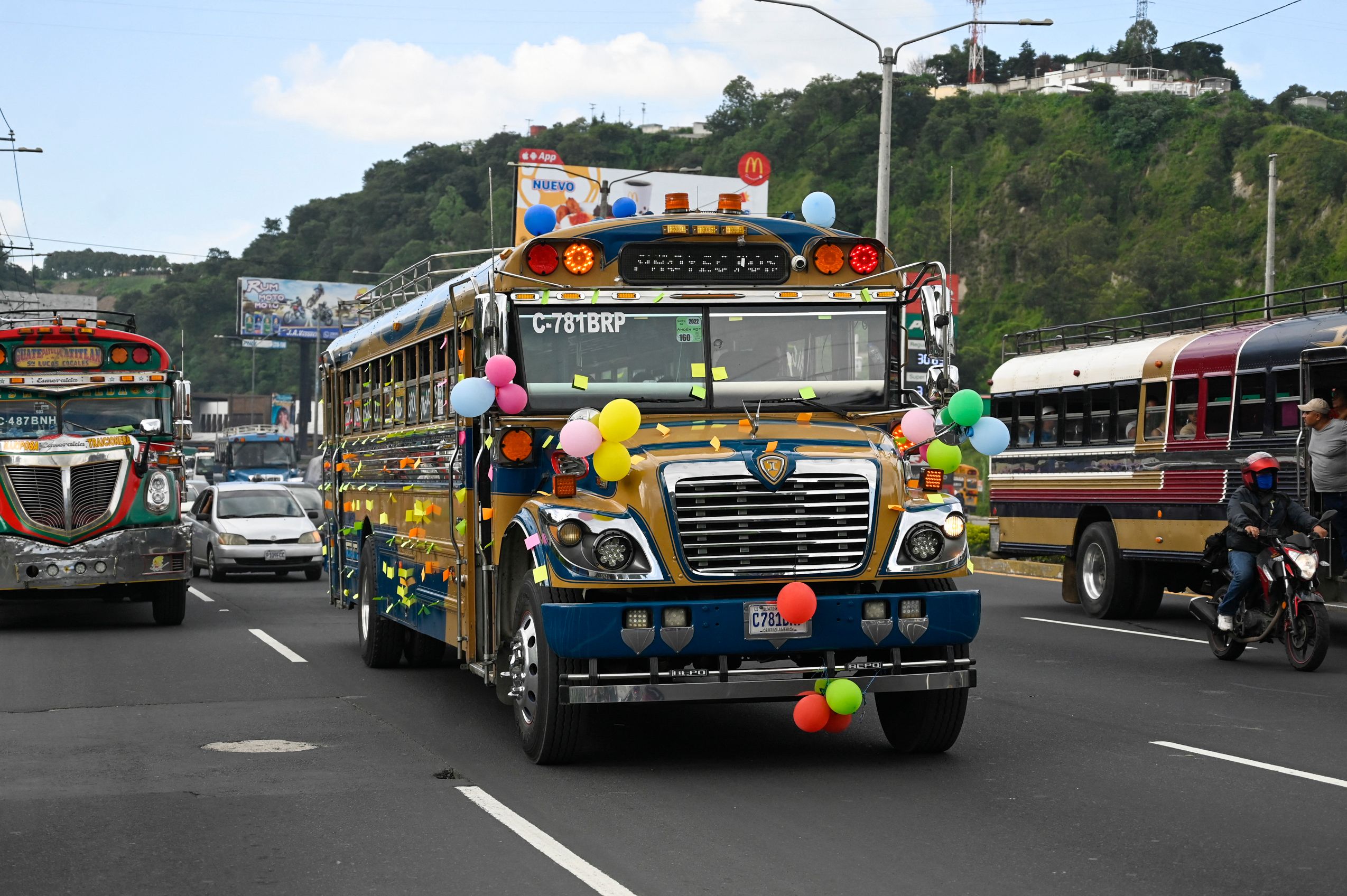 Public transportation system buses are adorned duriong the celebration of Saint Christopher's Day, patron saint of travellers and drivers, in Guatemala City on July 30, 2022. (Photo by Johan ORDONEZ / AFP)