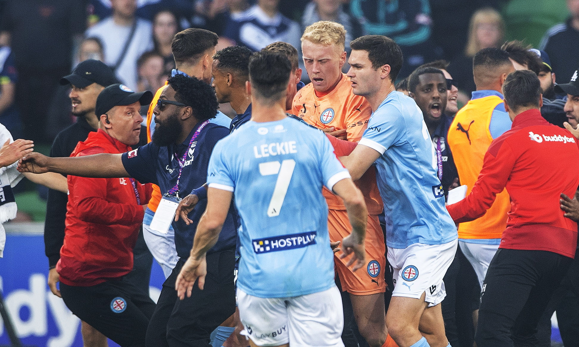 Tom Glover (centro) sangrando de Melbourne City es escoltado fuera del campo durante el partido de fútbol masculino de la A-League australiana entre Melbourne City y Melbourne Victory en AAMI Park en Melbourne, Australia, el 17 de diciembre de 2022. El partido fue abandonado después de que los fanáticos atacaron Glover en una violenta invasión de campo. Foto Prensa Libre (EFE)