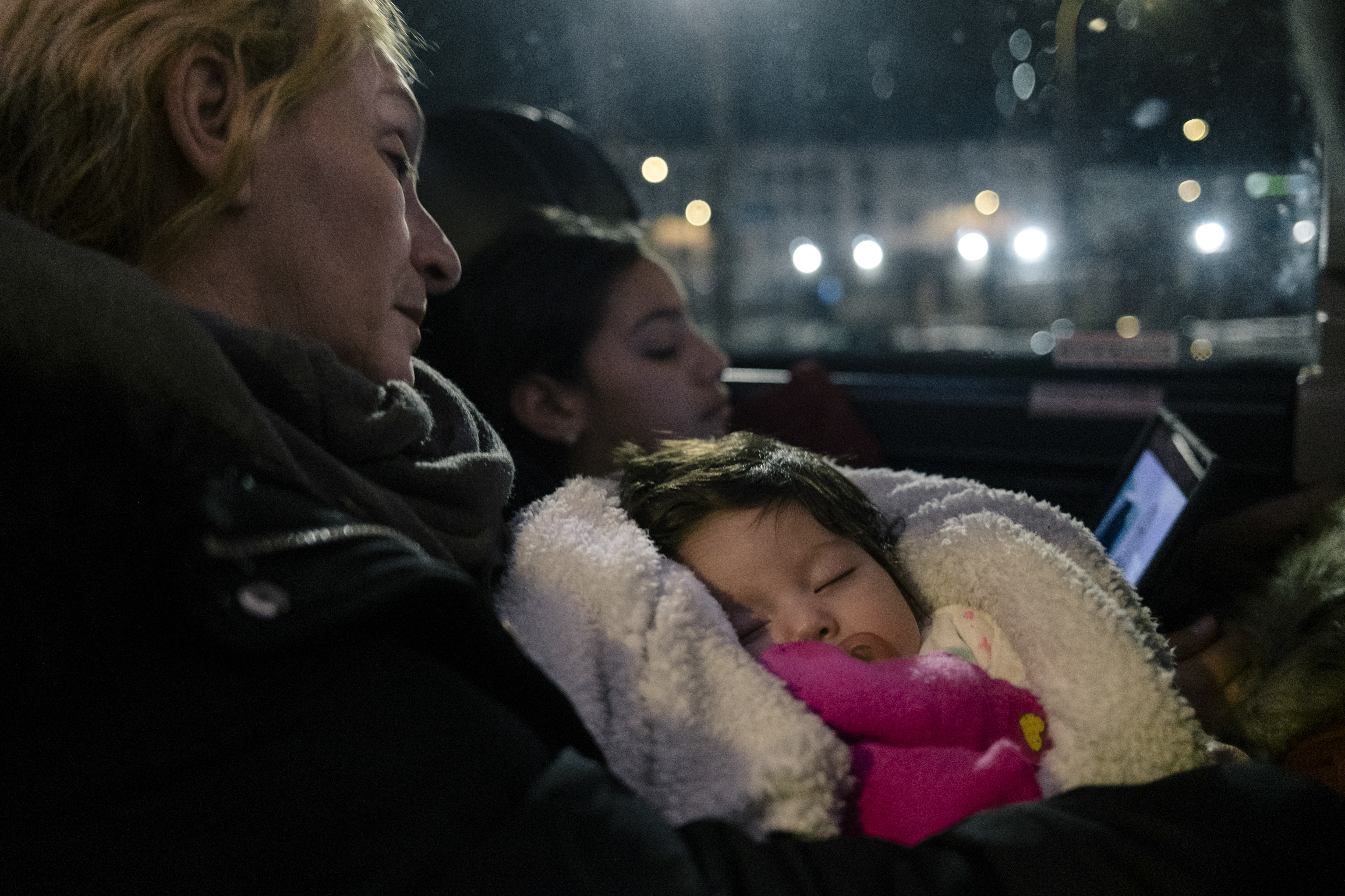 Elsa Brito, a la izquierda, sostiene a su nieta de dos meses, Amber Peña, mientras duermen a bordo de un autobús que se dirige a la frontera con Canadá, en Albany, Nueva York, el 5 de febrero de 2023. (Foto Prensa Libre: José A. Alvarado Jr./The New York Times)