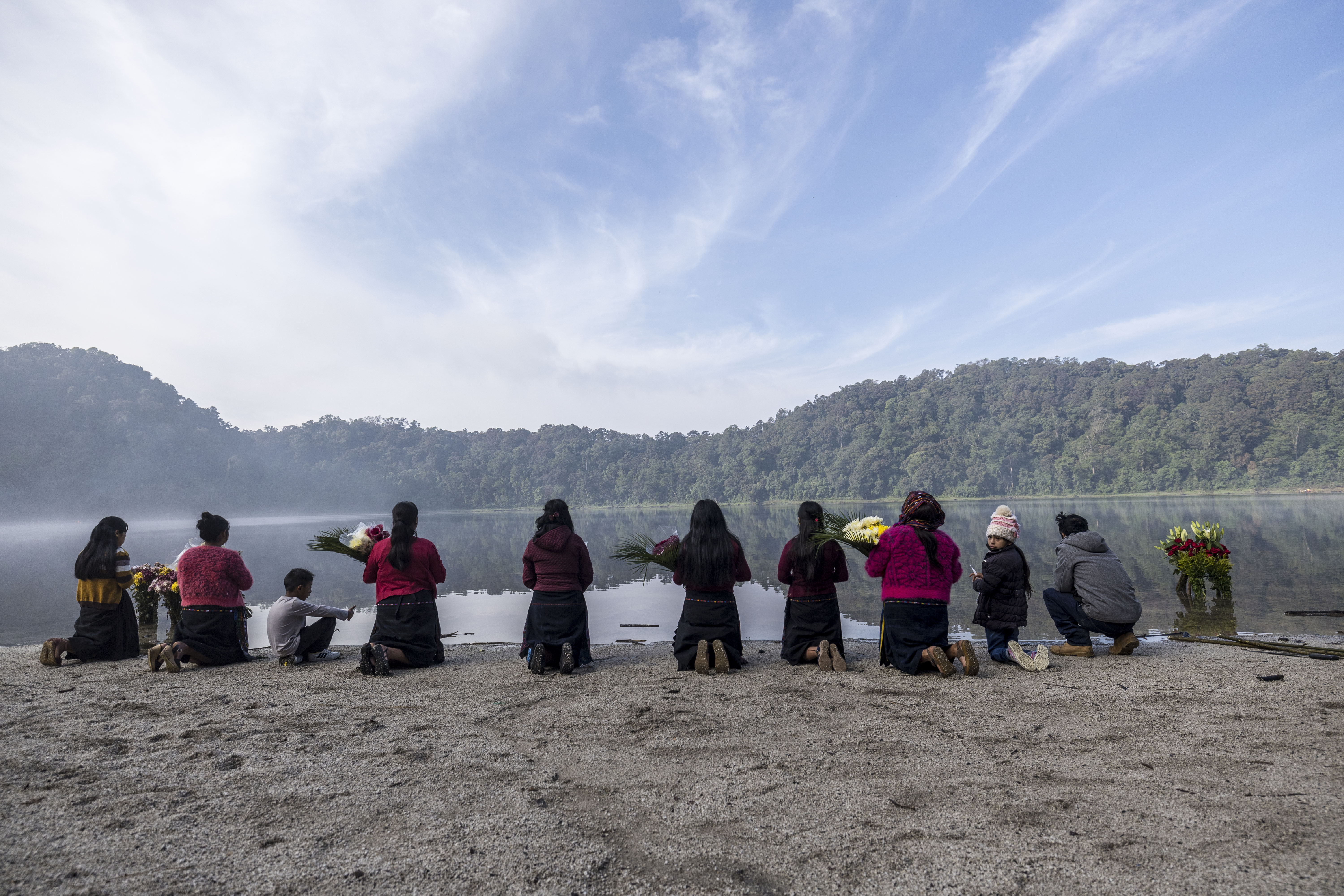 -FOTODELDÍA- AME021. CHICABAL (GUATEMALA), 18/05/2023.- Indígenas participan en una ceremonia en la que, con ofrendas florales, agradecen a la naturaleza por la lluvia, hoy, en la laguna de Chicabal (Guatemala). Esta laguna, considerada sagrada por el pueblo maya mam, está asentada en el cráter del volcán Chicabal a 2.000 metros de altura sobre el nivel del mar y se ubica en el departamento (provincia) de Quetzaltenango, 220 kilómetros al oeste de la Ciudad de Guatemala. Esta costumbre, con cientos de años de historia, es considerada por los guías espirituales mayas como una ceremonia que conecta a los creyentes con la naturaleza y sus ancestros. EFE/ Esteban Biba