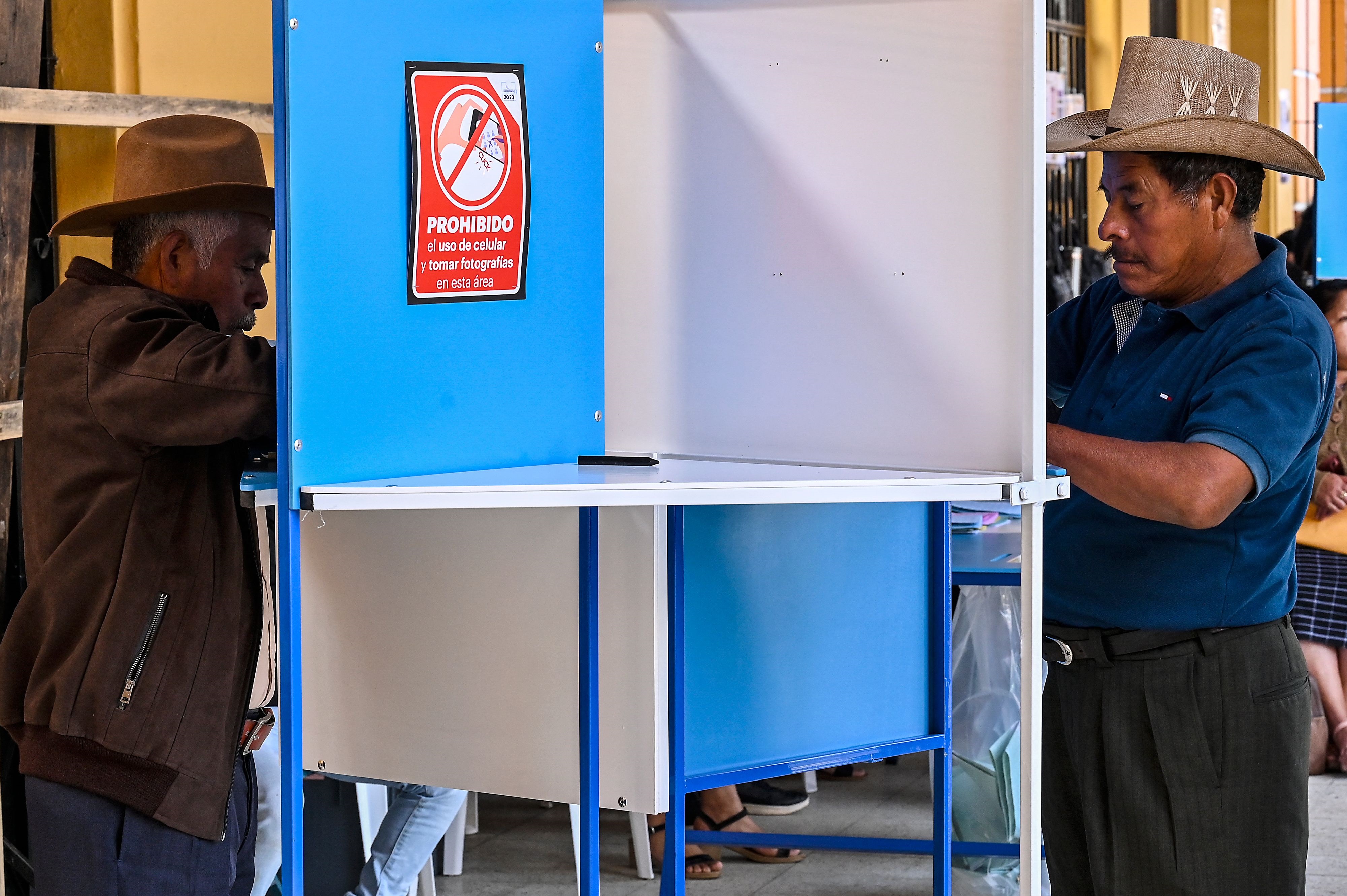 Dos hombres emiten su sufragio en San Juan Sacatepéquez, departamento de Guatemala. El proceso electoral ha llamado la atención de los medios internacionales. (Foto Prensa Libre)