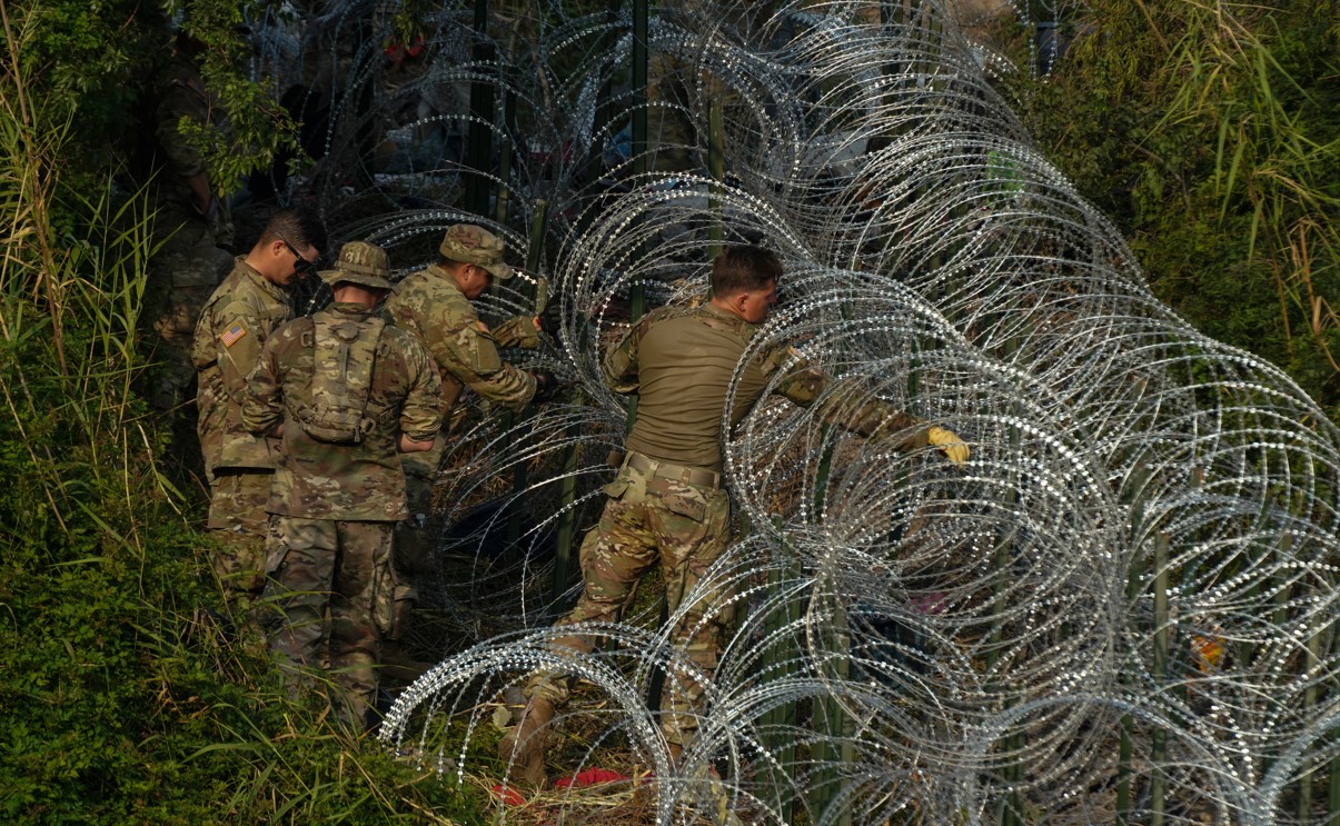 Soldados colocan una línea de alambre concertina en un punto de cruce fronterizo cerca de Brownsville, Texas, el 11 de mayo de 2023. (Verónica G. Cárdenas/The New York Times)