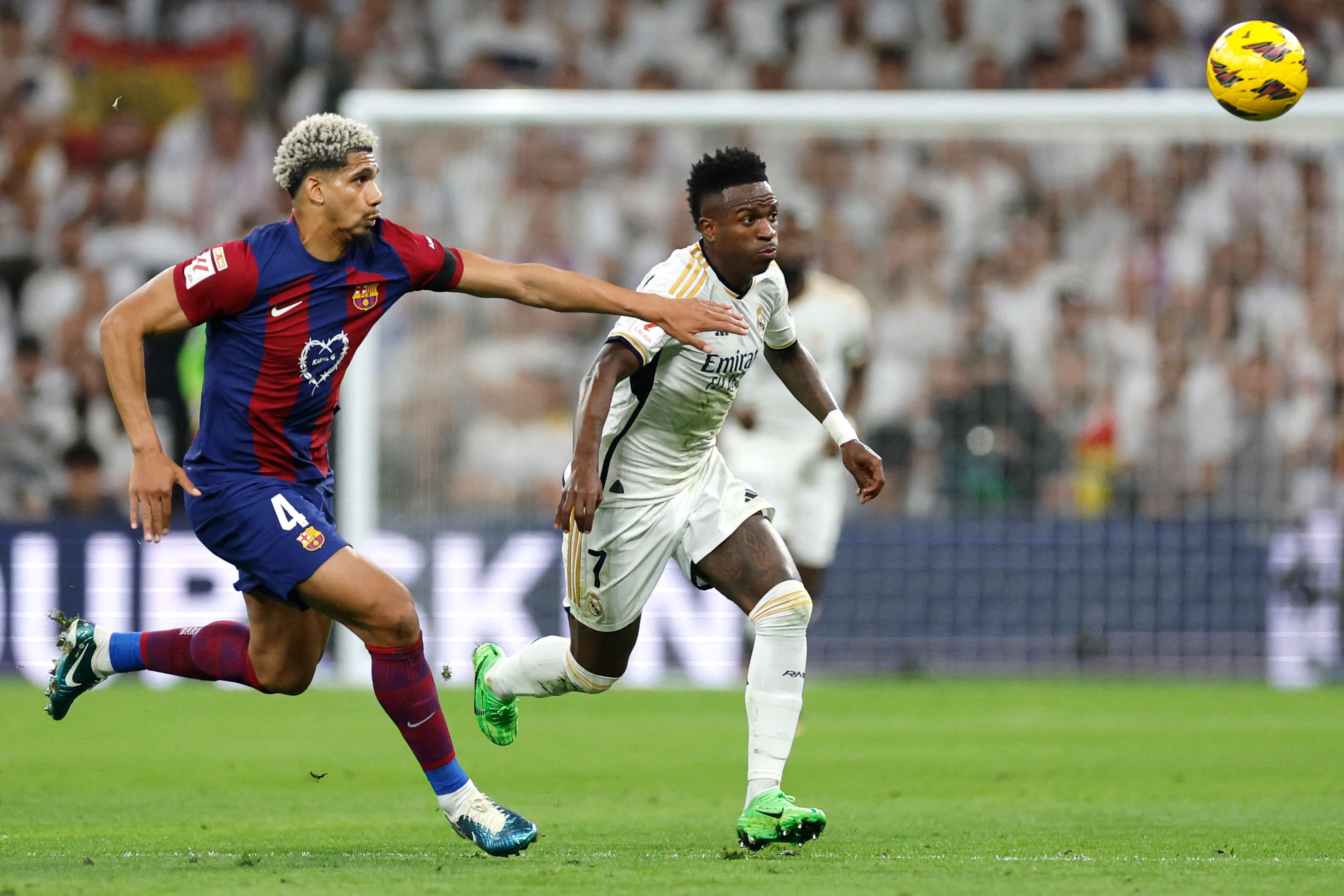 Ronald Araujo lucha por el balón contra Vinícius Junior del Real Madrid.