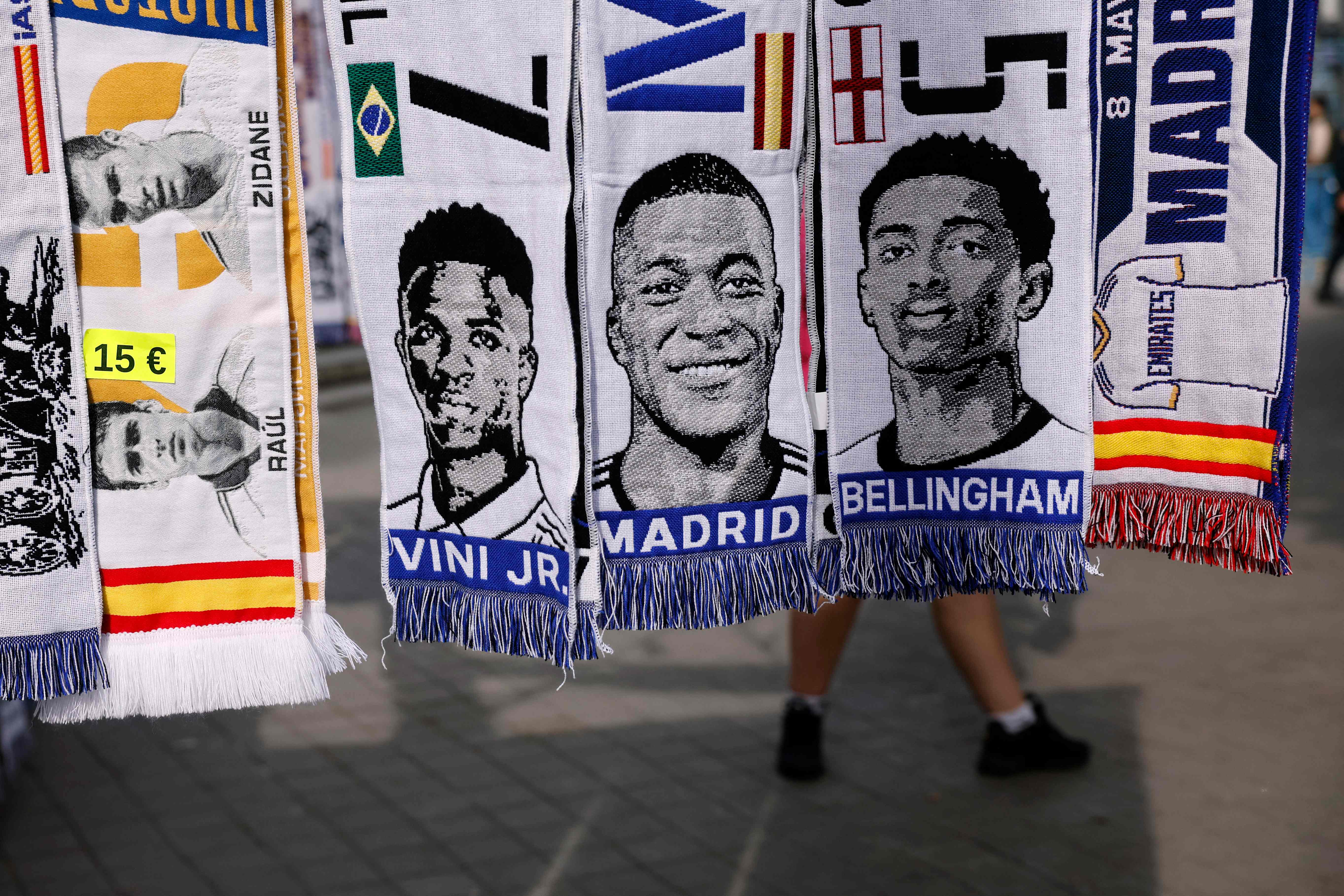 Bufandas que representan a futbolistas como Jude Bellingham, Vinicius Junior o Kylian Mbappé en un puesto de vendedores ambulantes.