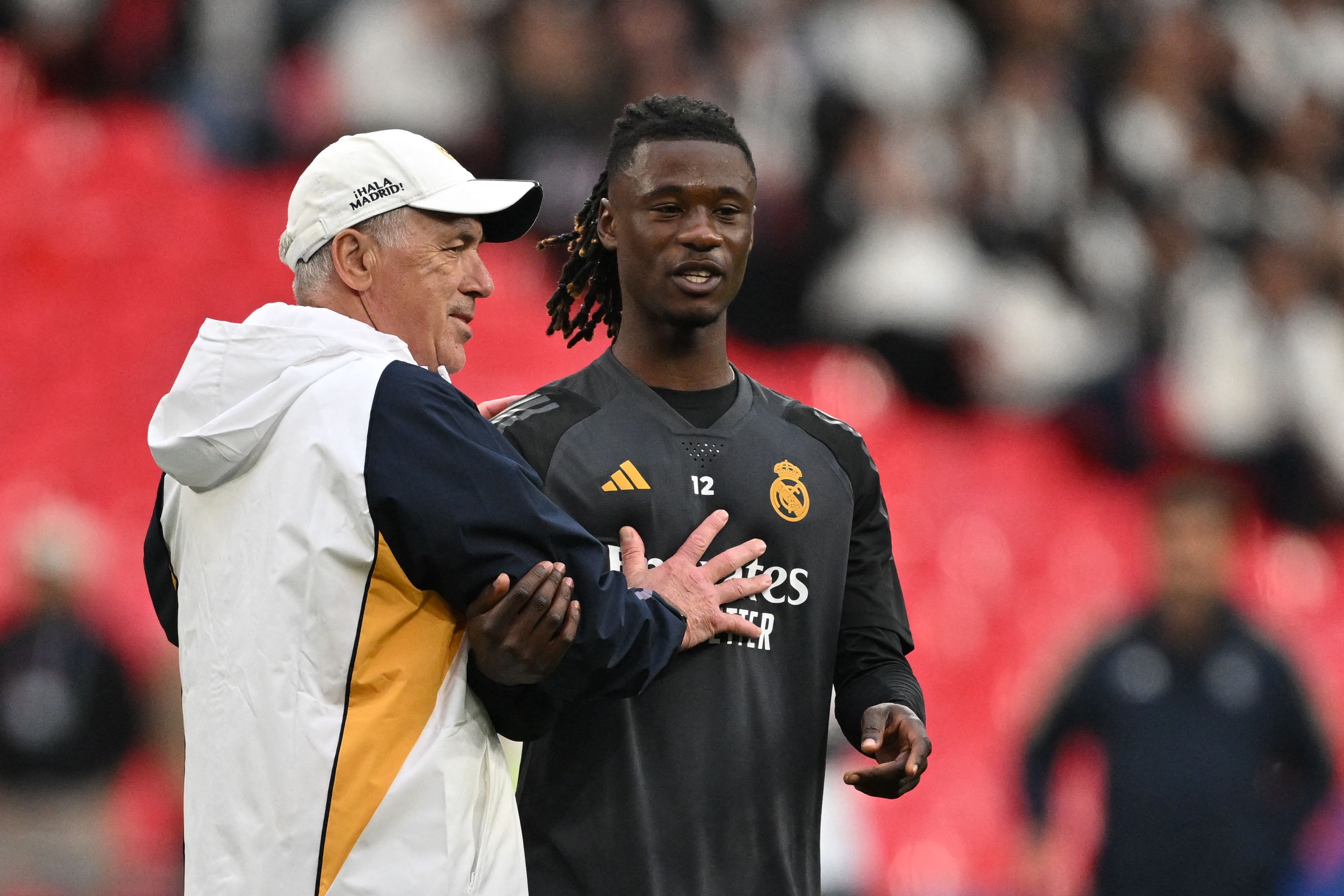 El entrenador del Real Madrid, Carlo Ancelotti, habla con el defensa francés, Eduardo Camavinga, antes de la final de la final de la UEFA Champions League contra el Borussia Dortmund. (Foto Prensa Libre: AFP)