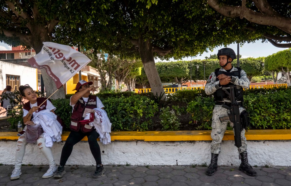 Miembros de la Guardia Nacional y seguridad privada escoltan a miembros del partido Morena en Celaya, México, este mes. (Cesar Rodriguez/The New York Times)