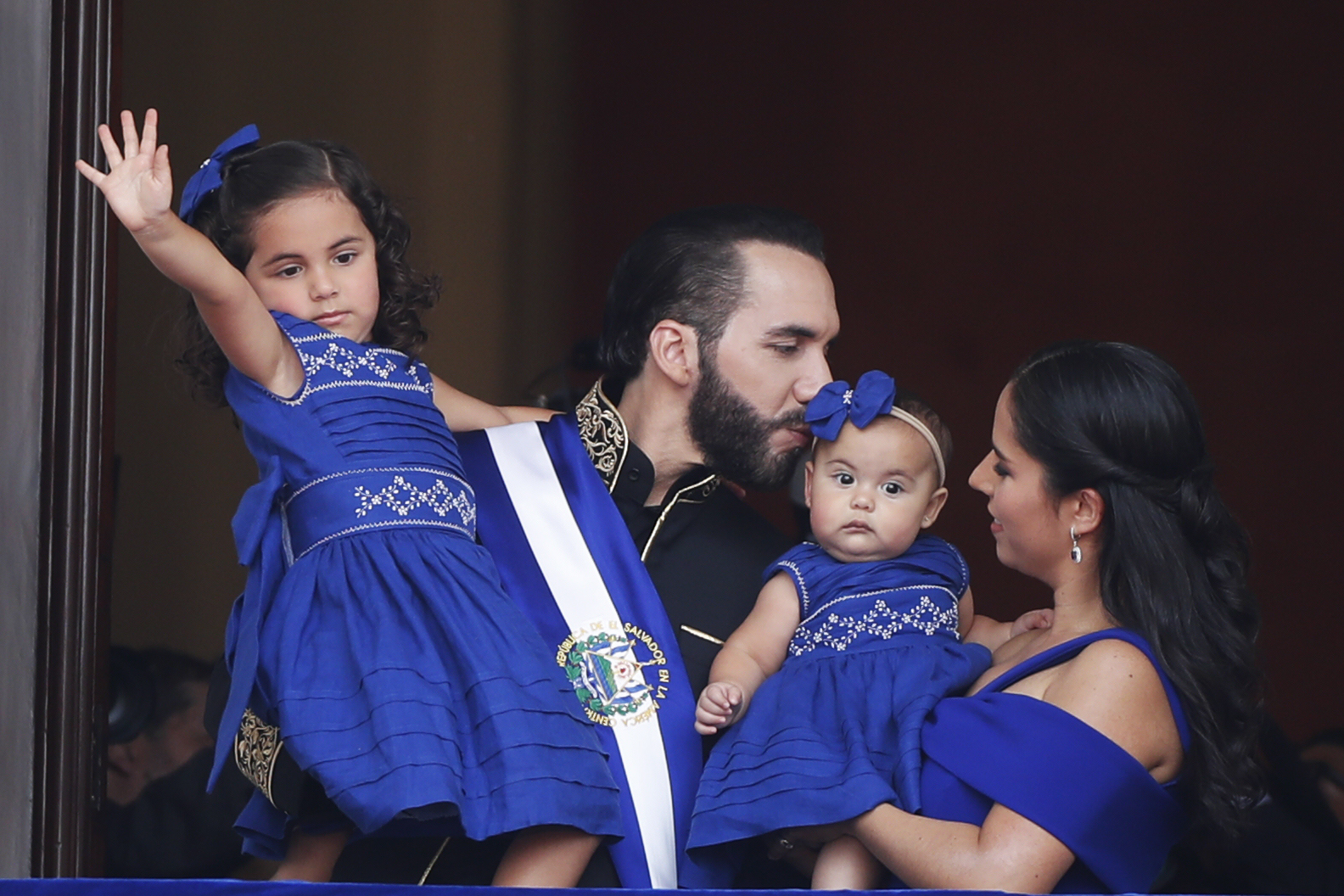 El presidente de El Salvador, Nayib Bukele, acompañado de su esposa, Gabriela Rodríguez, y de sus hijas saluda a los asistentes a la ceremonia de investidura para su segundo mandato, este sábado en la Plaza Gerardo Barrios de San Salvador.   (Foto Prensa Libre: EFE)