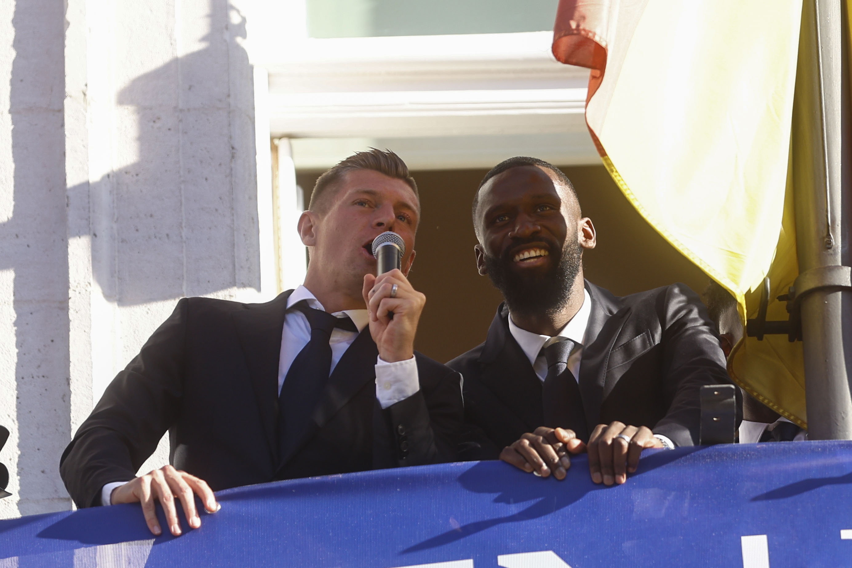 Los jugadores del Real Madrid Antonio Rudiger y Toni Kroos (i) saludan a los aficionados desde del balcón de la Real Casa de Correos, sede de la Comunidad de Madrid, segunda parada del recorrido realizado este domingo por el equipo para celebrar su victoria en la final de la Liga de Campeones. (Foto Prensa Libre: EFE)