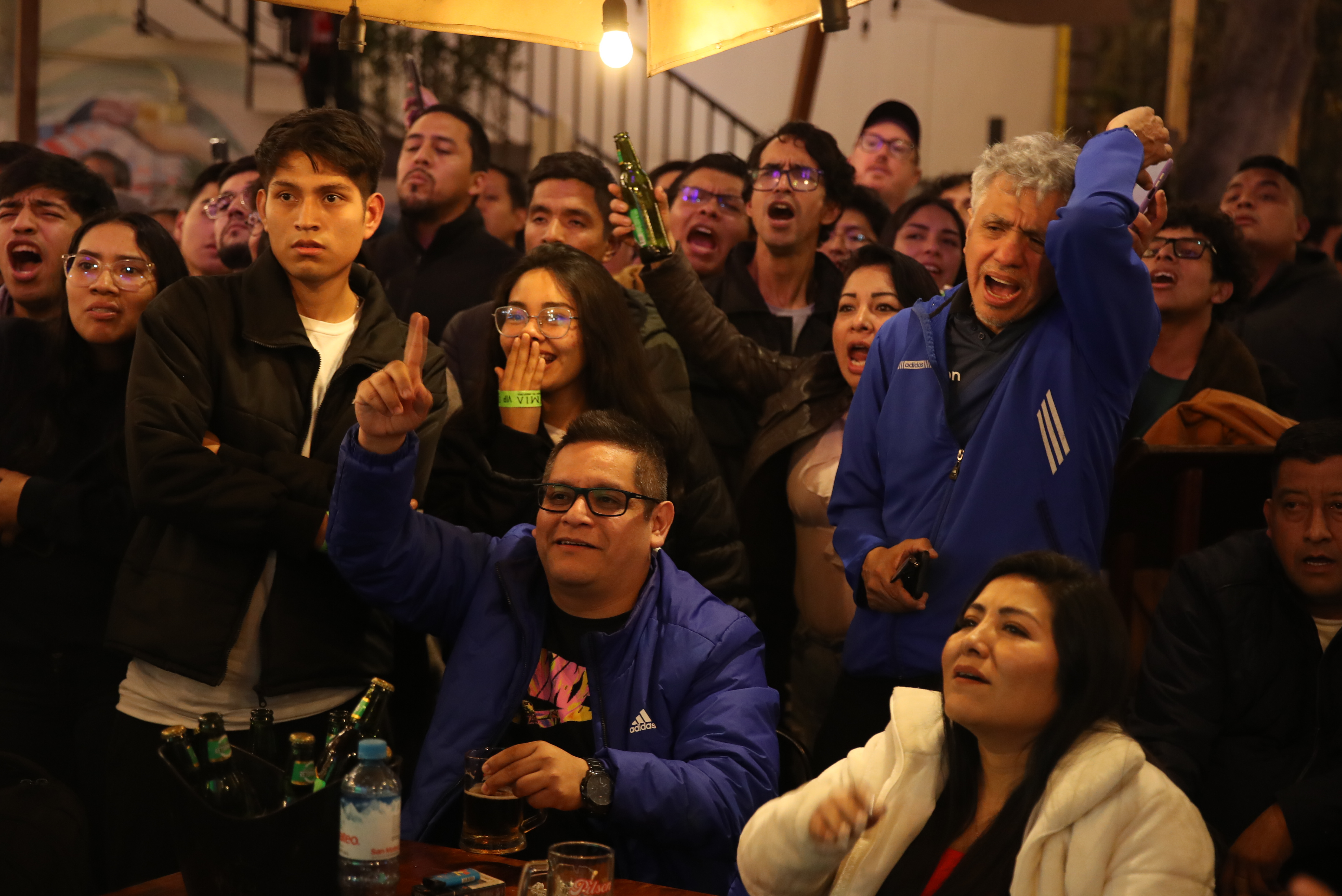 Aficionados reaccionan durante la transmisión del partido de la fase de grupos de la Copa América entre Perú y Chile.  (Foto Prensa Libre ; EFE) 