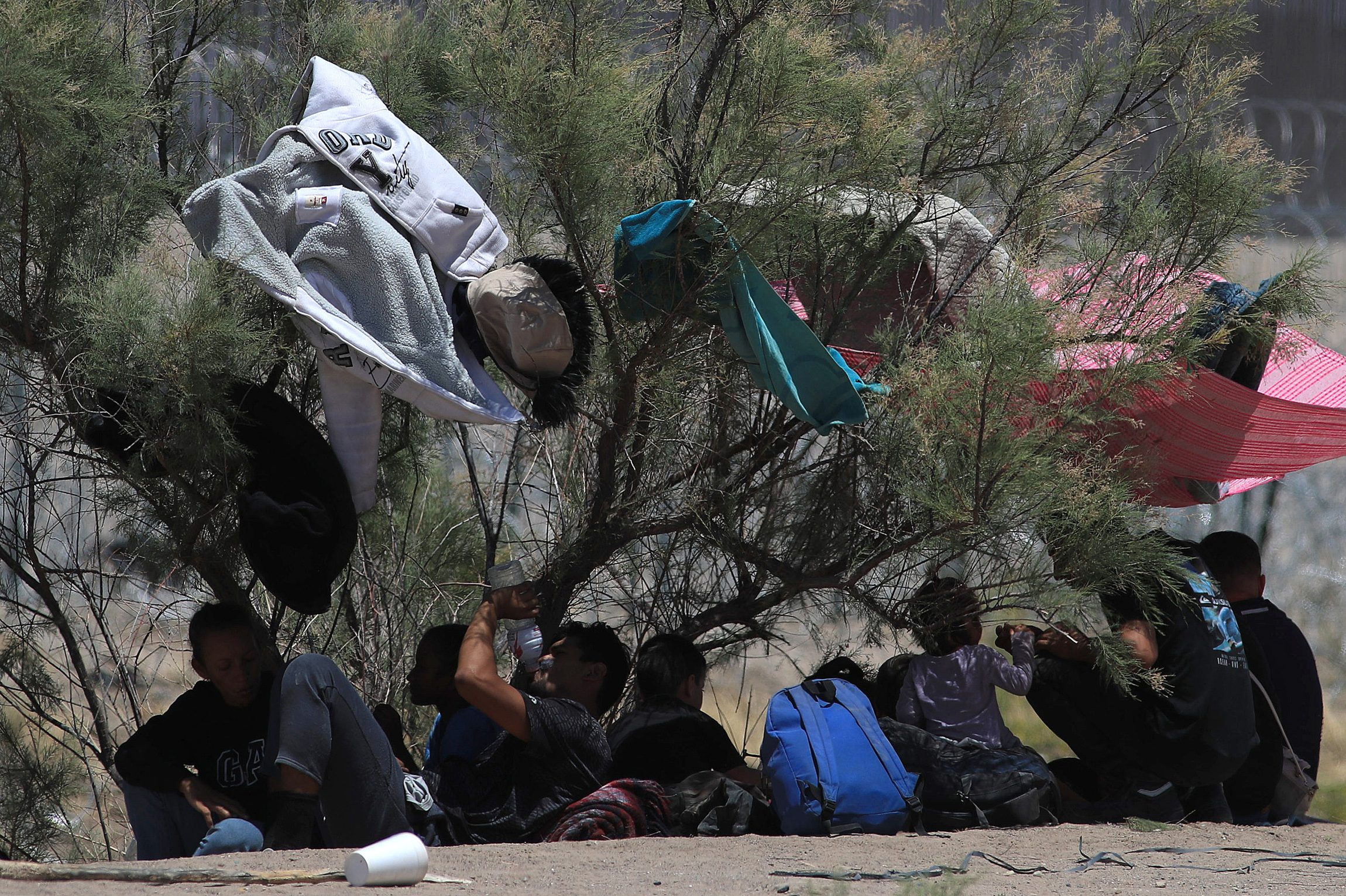 Migrantes se resguardan en la sombra, el pasado jueves 30 de mayo en Ciudad Juárez. (Foto Prensa Libre. EFE/ Luis Torres9