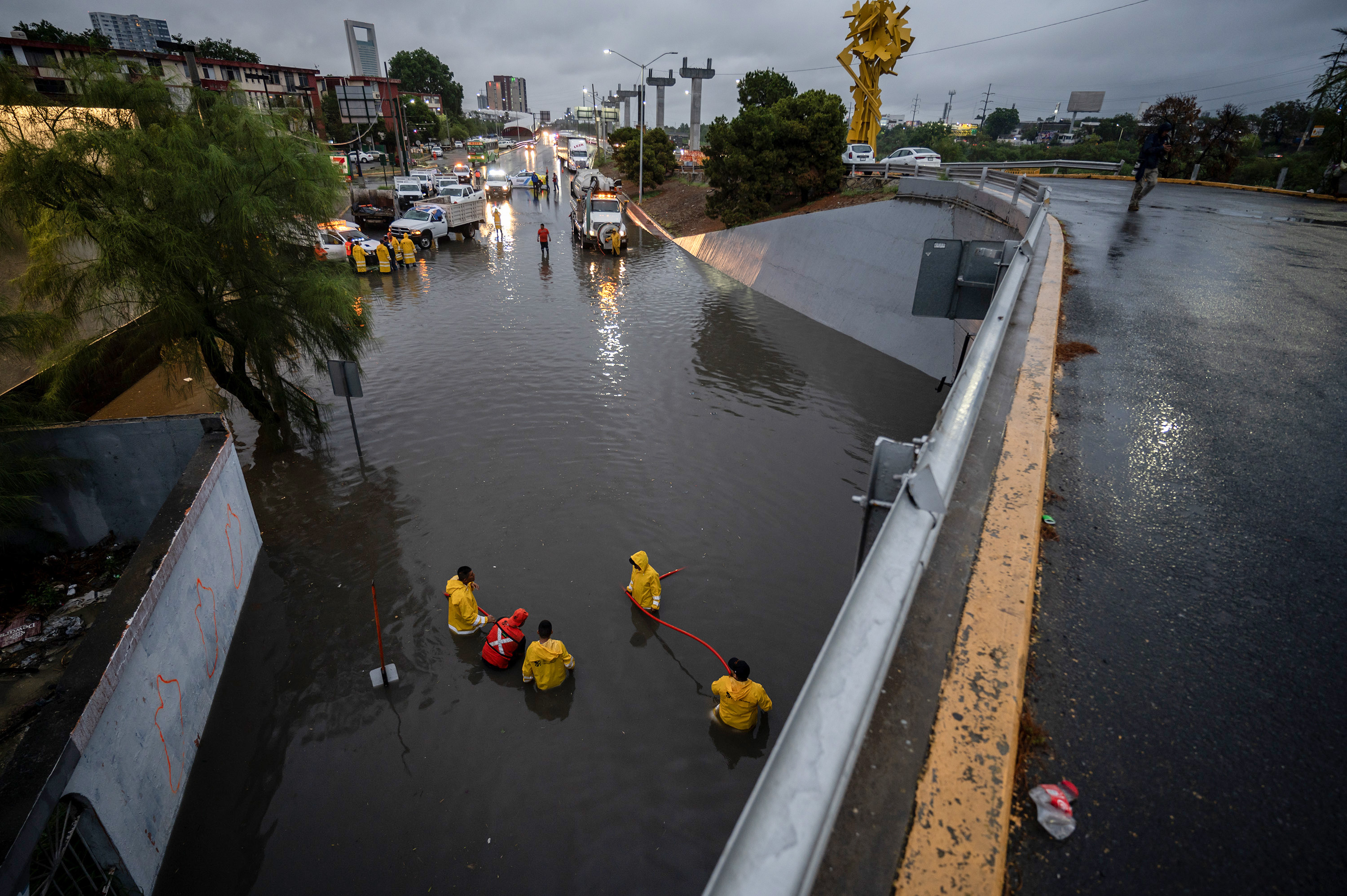 Integrantes de Protección Civil trabajan en un desnivel inundado debido a las fuertes lluvias este miércoles, en la ciudad de Monterrey (Foto Prensa Libre: EFE/Miguel Sierra)