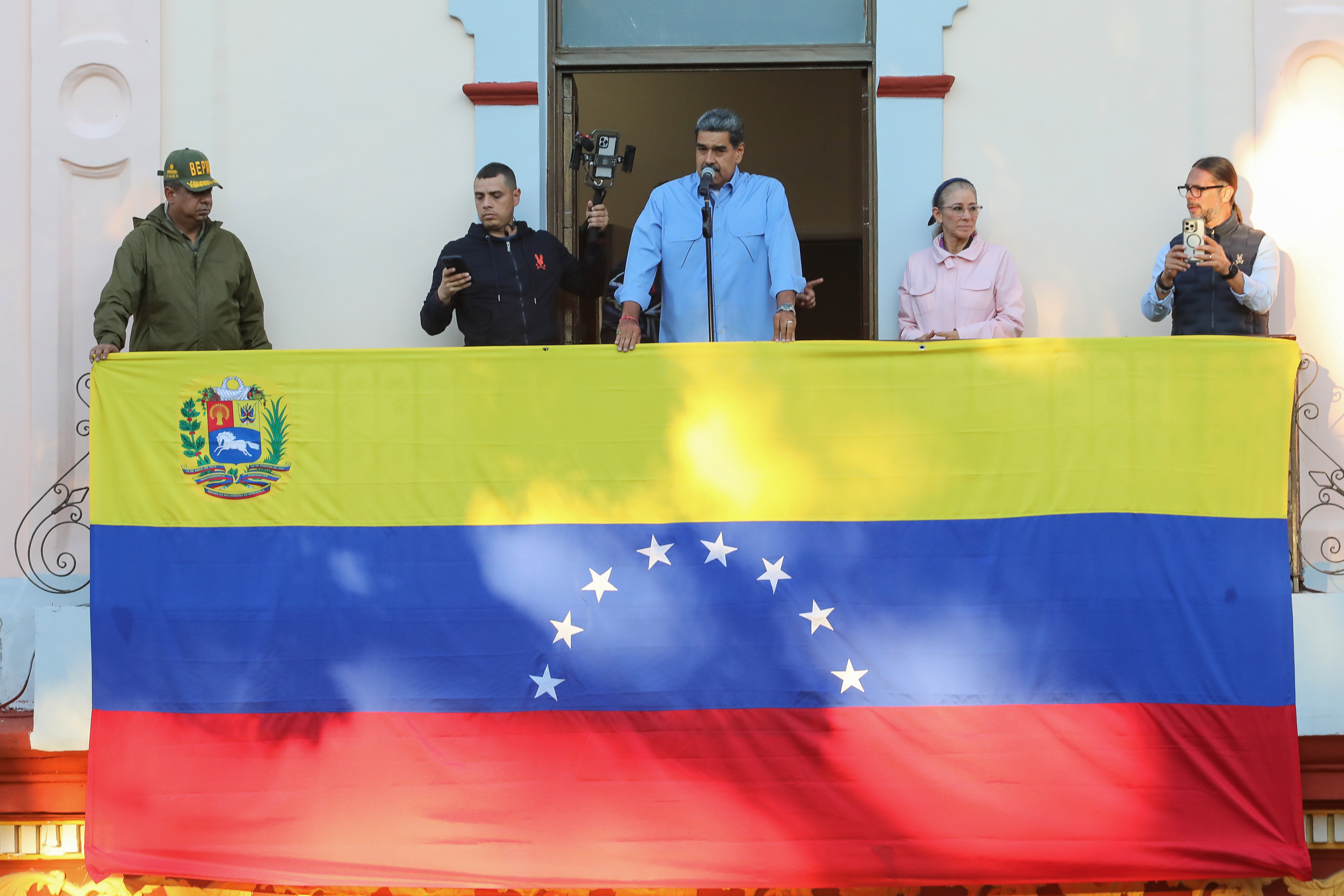 Fotografía cedida este martes por Prensa Miraflores del presidente de Venezuela, Nicolás Maduro (c), durante su discurso desde el balcón del pueblo ubicado en el Palacio de Miraflores, en Caracas. (Foto Prensa Libre: EFE/ Prensa Miraflores)