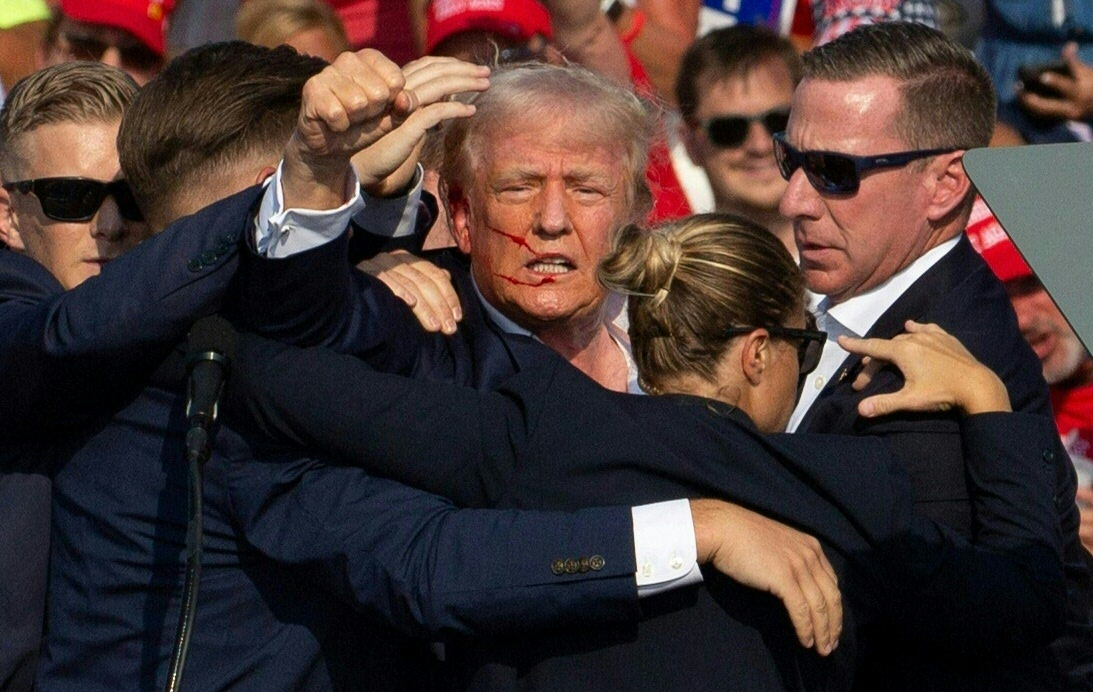 Donald Trump durante la evacuación que hizo el Servicio Secreto tras el ataque armado que sufrió el expresidente, en Pensilvania, en donde una bala le impactó en la oreja.  (Foto Prensa Libre: AFP)