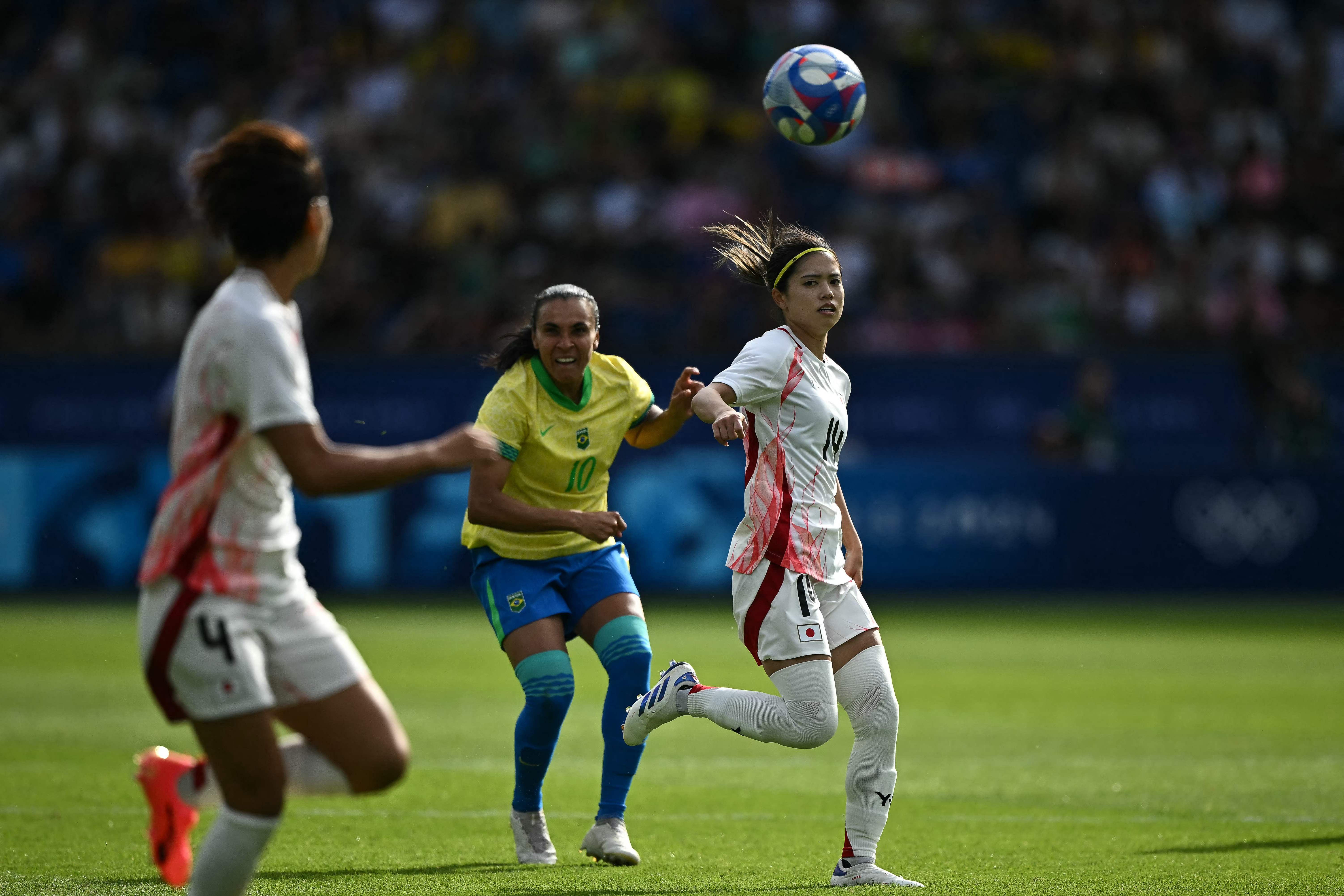 Japan's midfielder #14 Yui Hasegawa fights for the ball with Brazil's forward #10 Marta in the women's group C football match between Brazil and Japan during the Paris 2024 Olympic Games at the Parc des Princes in Paris on July 28, 2024. (Photo by Ben STANSALL / AFP)