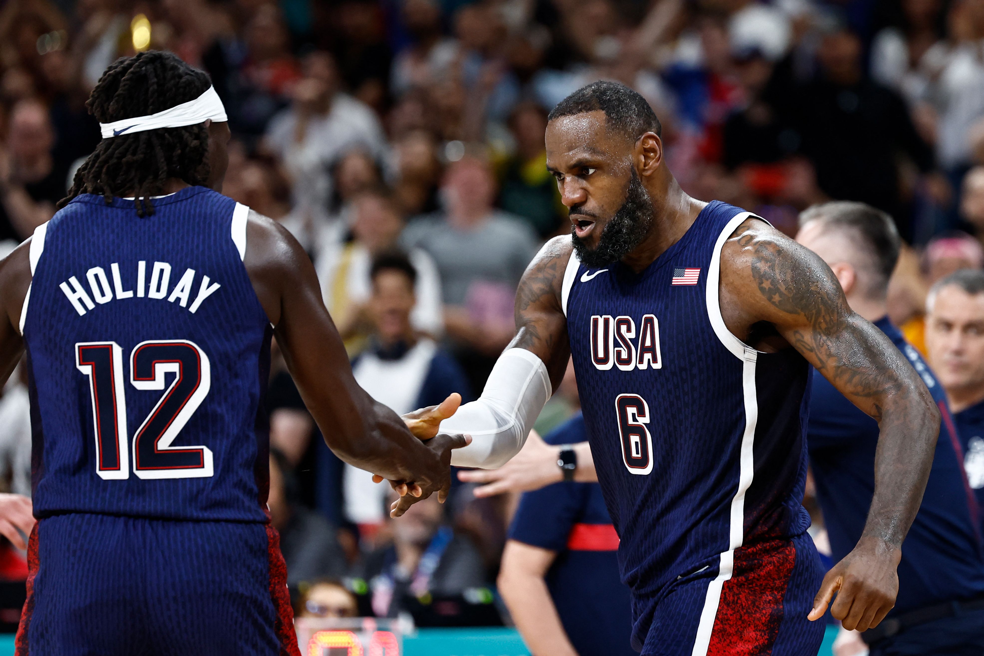 LeBron James celebra junto a Holiday (12) la victoria ante Serbia