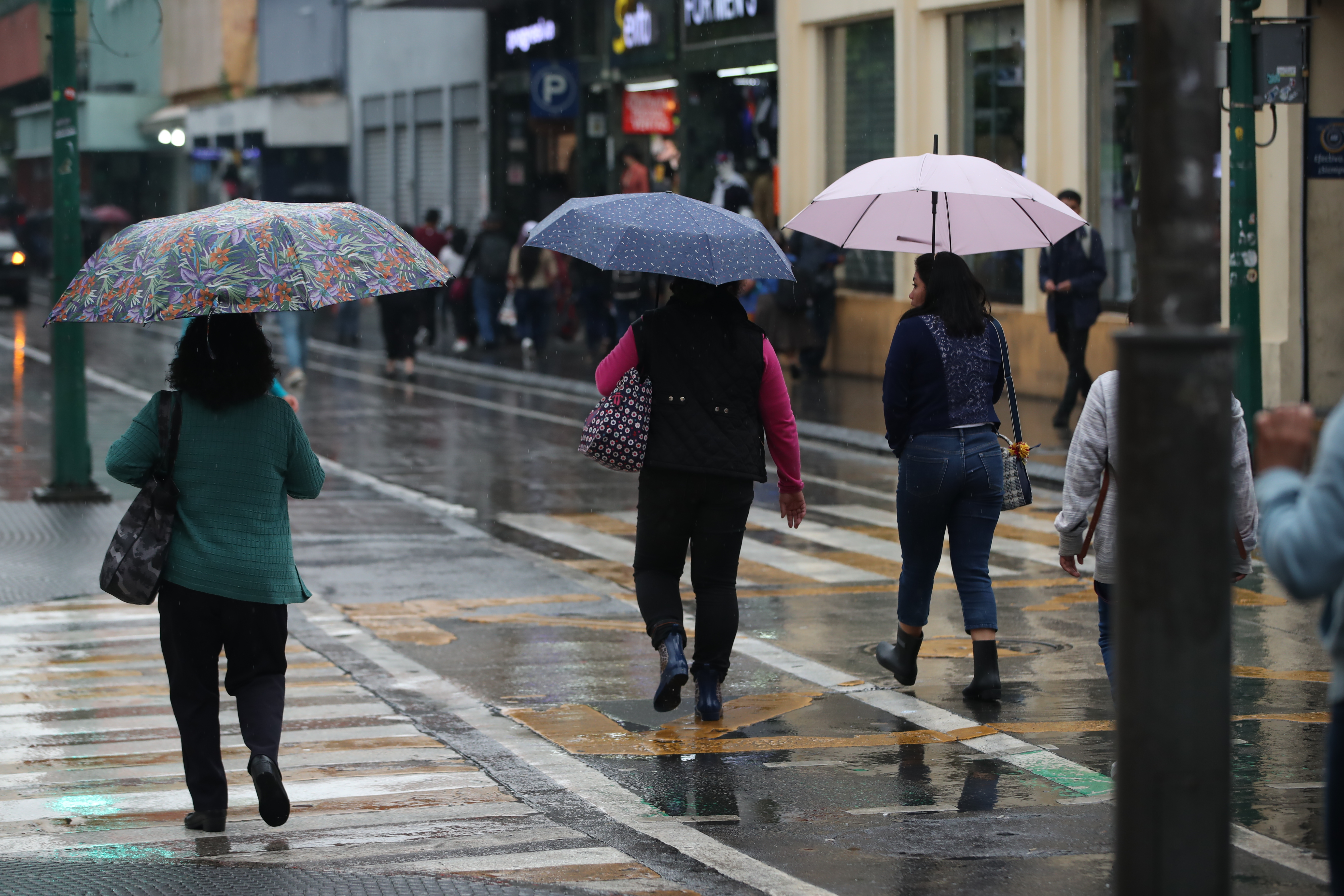 Guatemaltecos se resguardan de la lluvia en la sexta avenida. 

Fotografía Prensa Libre: María José Bonilla
Fecha: 23/10/2023