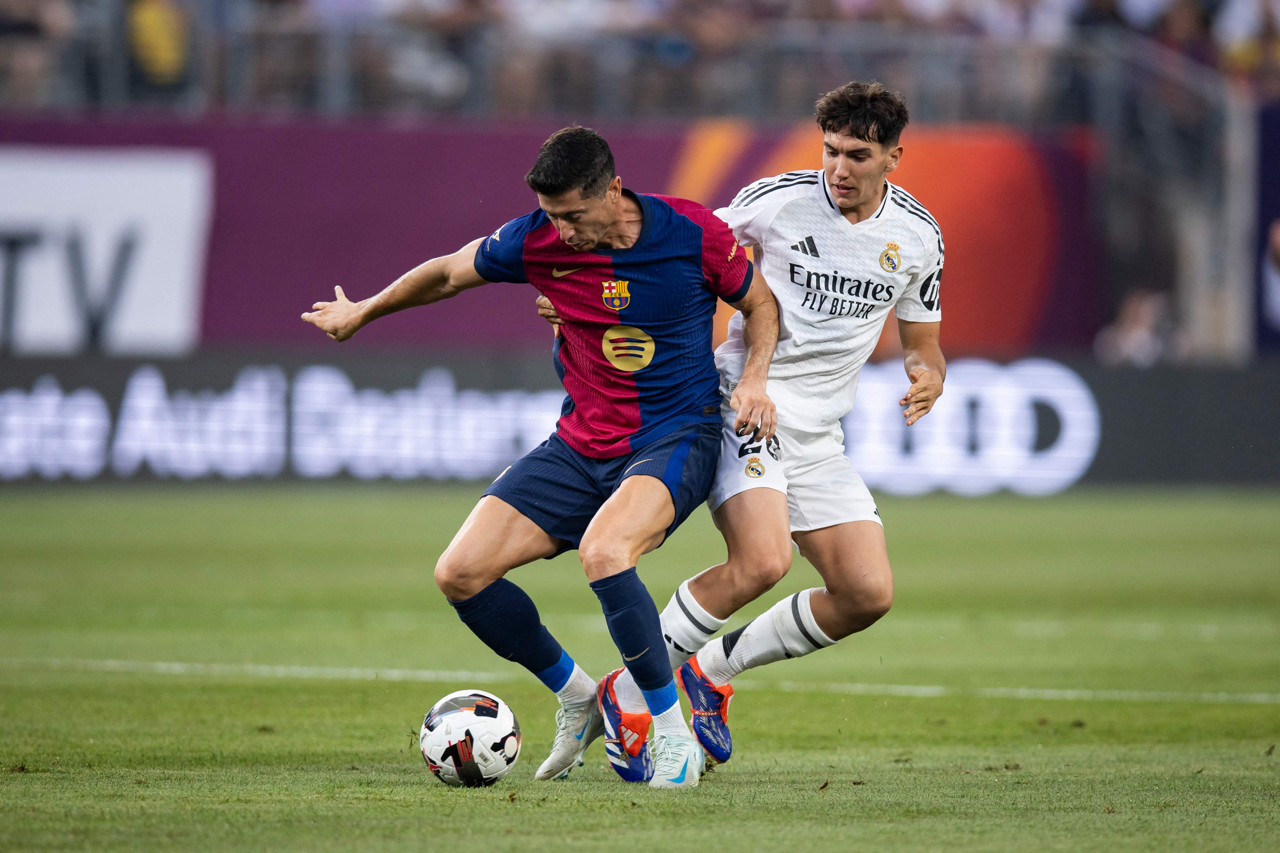 EAST RUTHERFORD, NEW JERSEY - AUGUST 3: Robert Lewandowski #9 of FC Barcelona battles for control of the ball against Brahim Abdelkader #21 of Real Madrid in the first half of the pre-season friendly at MetLife Stadium on August 3, 2024 in East Rutherford, New Jersey.   Ira L. Black/Getty Images/AFP (Photo by Ira L. Black / GETTY IMAGES NORTH AMERICA / Getty Images via AFP)