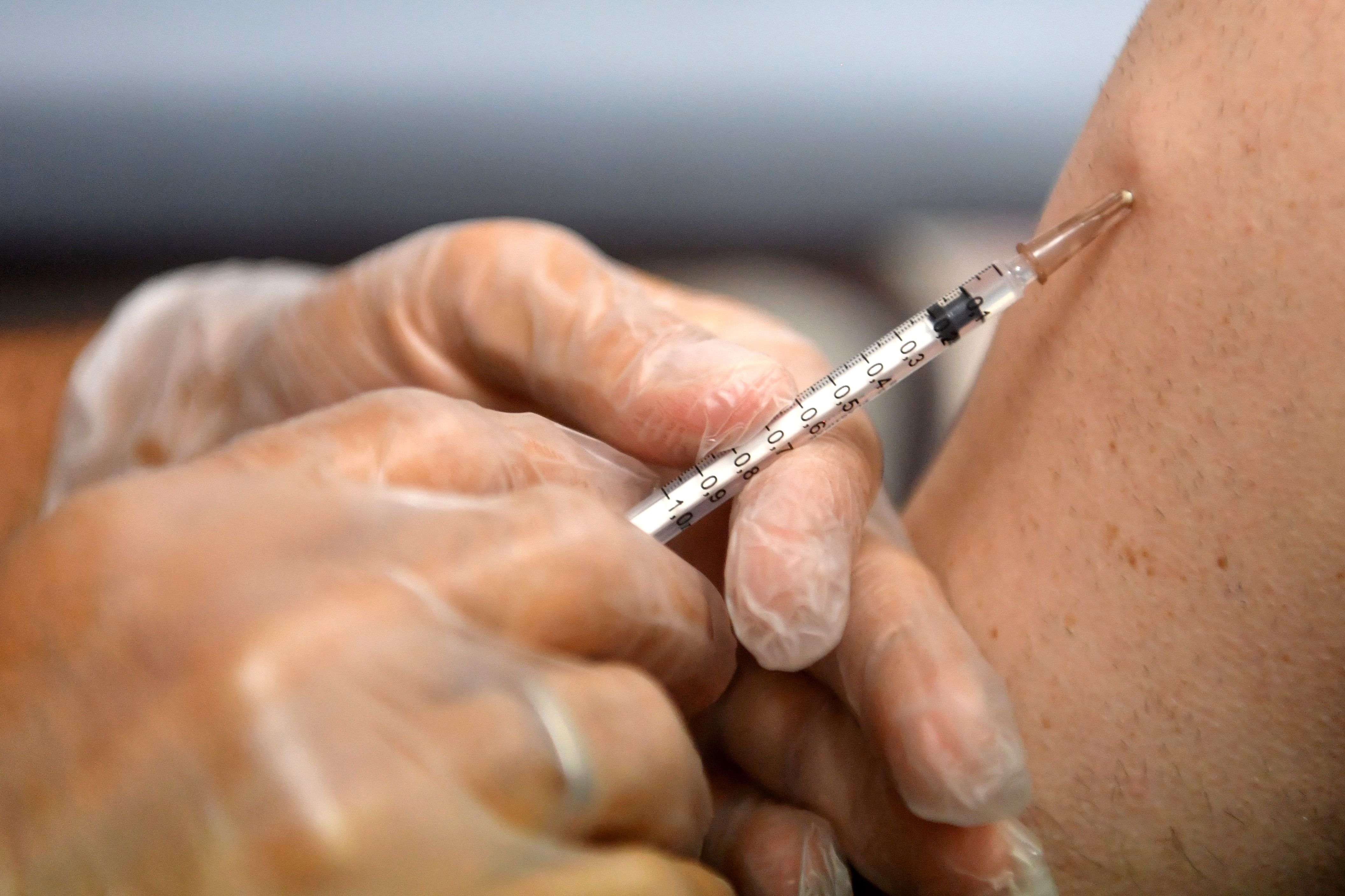 (FILES) This file photo taken on August 10, 2022 shows a pharmacist administering a dose of Imvanex, a vaccine to protect against Monkeypox virus, at a pharmacy in Lille, northern France. Shares of the pharmaceutical laboratories of Bavarian Nordic in Denmark, which manufactures a specific vaccine against the mpox, jumped up on August 15, 2024 following the decision of the World Organization of Health WHO to consider the resurgence of monkeypox cases together with an urgent need for health care in the world. A surging mpox outbreak in Africa, which was declared an emergency by the continent's health agency on August 13, is being driven by a new, more transmissible strain of the virus. The Africa Centres for Disease Control and Prevention (Africa CDC) declared its first-ever Public Health Emergency of Continental Security (PHECS) for the deadly disease. (Photo by FRANCOIS LO PRESTI / AFP)