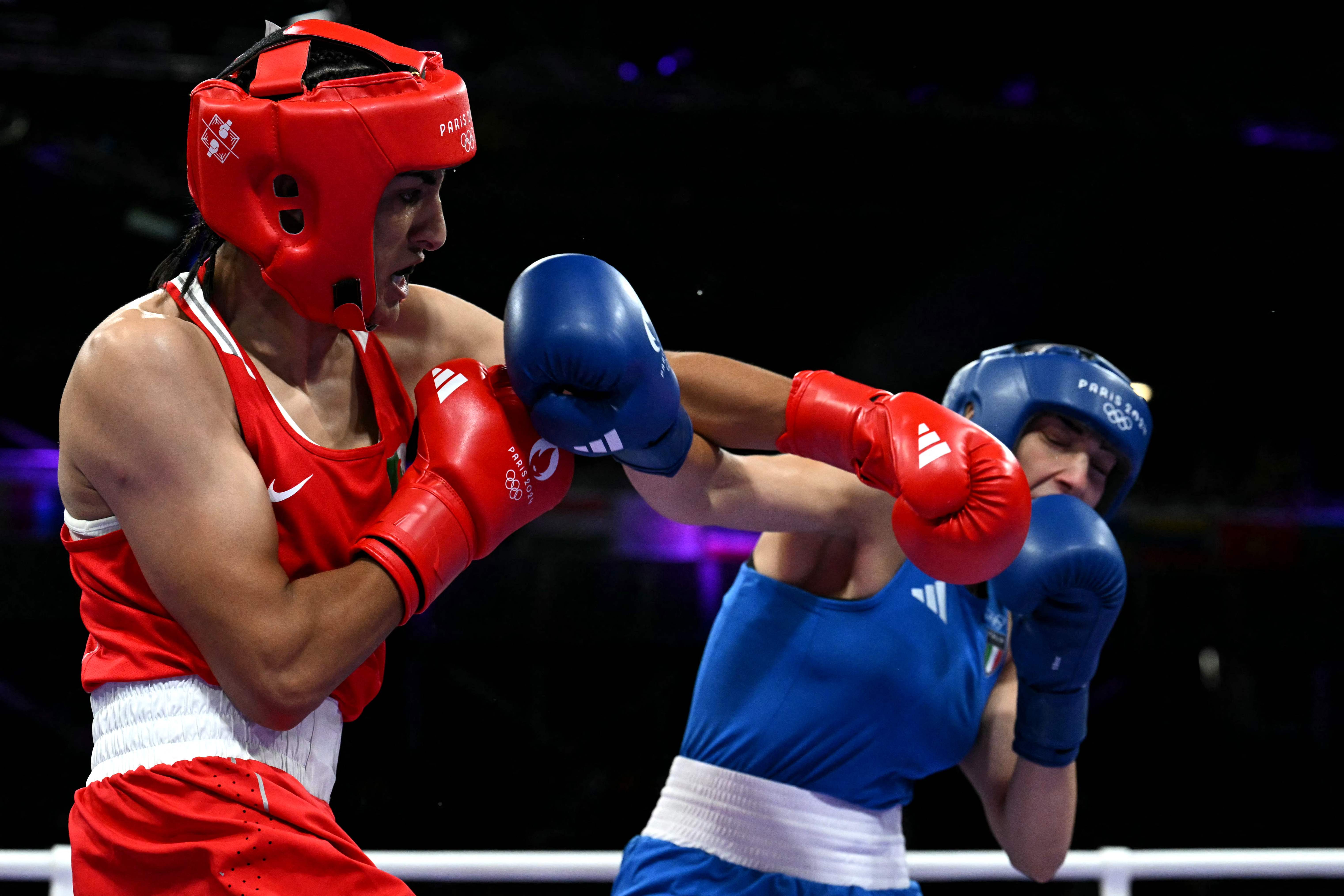 La argelina Imane Khelif (de rojo) golpea a la italiana Angela Carini en el combate de boxeo de octavos de final de la preliminar femenina de 66 kg durante los Juegos Olímpicos de París 2024 en el North Paris Arena, en Villepinte, el 1 de agosto de 2024. (Foto Prensa Libre: MOHD RASFAN / AFP)