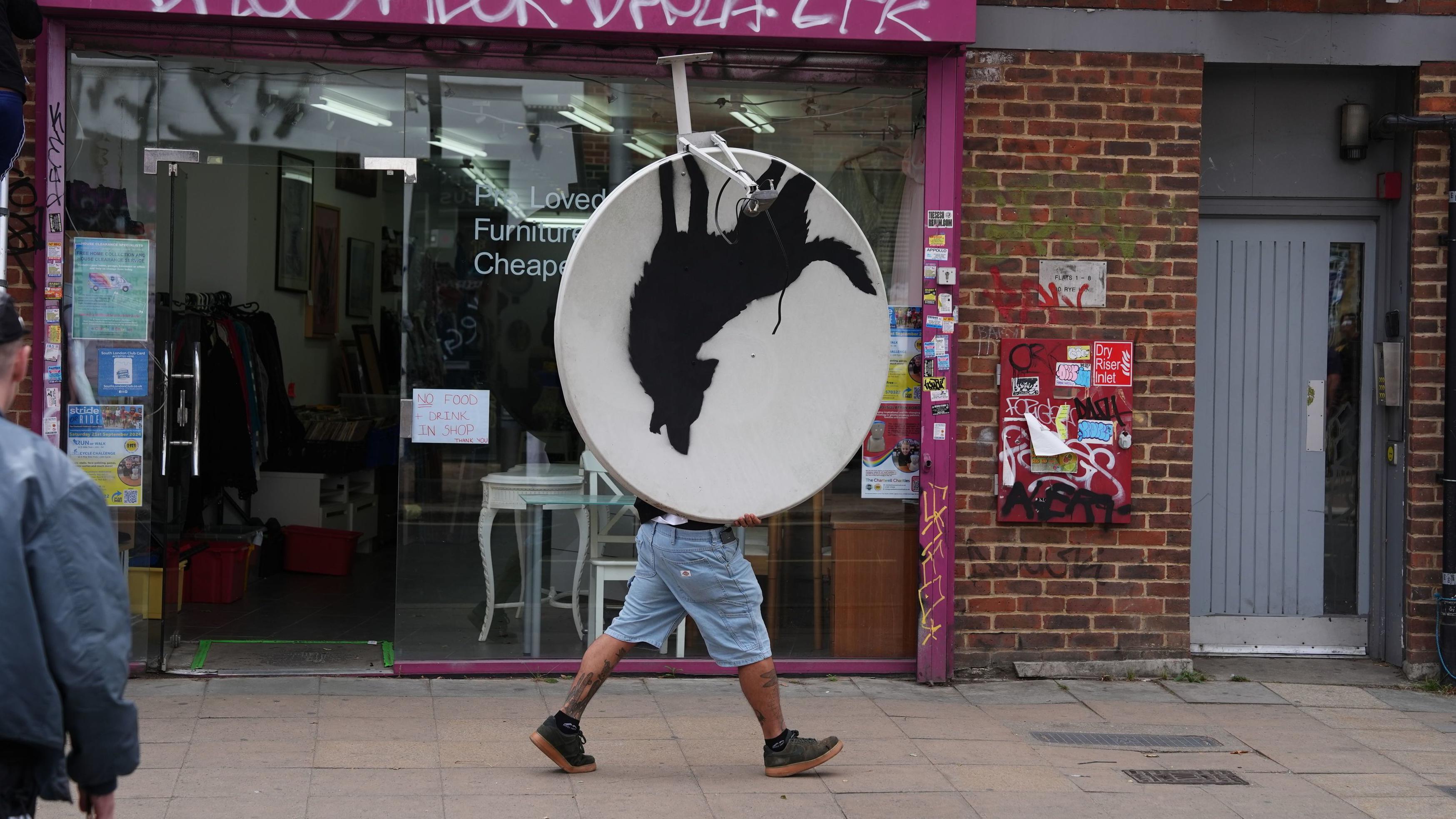 Un hombre se lleva campante la antena parabólica en la que Banksy pintó un lobo aullando