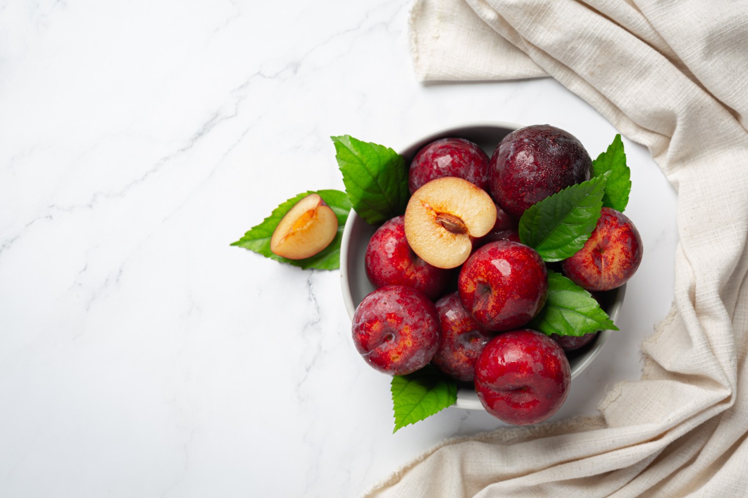 ¿Las ciruelas ayudan a combatir el estreñimiento? Esto explican los expertos Red-plum-put-white-bowl-white-floor