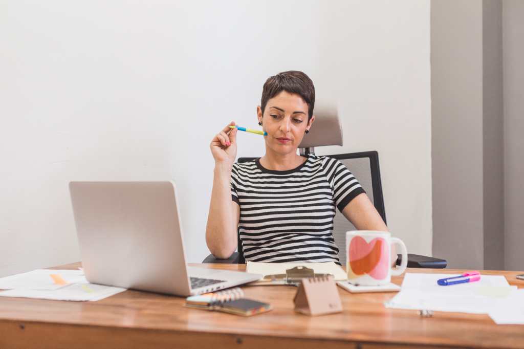 Una mujer frente a su computadora mediando y organizando los pagos de impuestos que corresponde pagar.