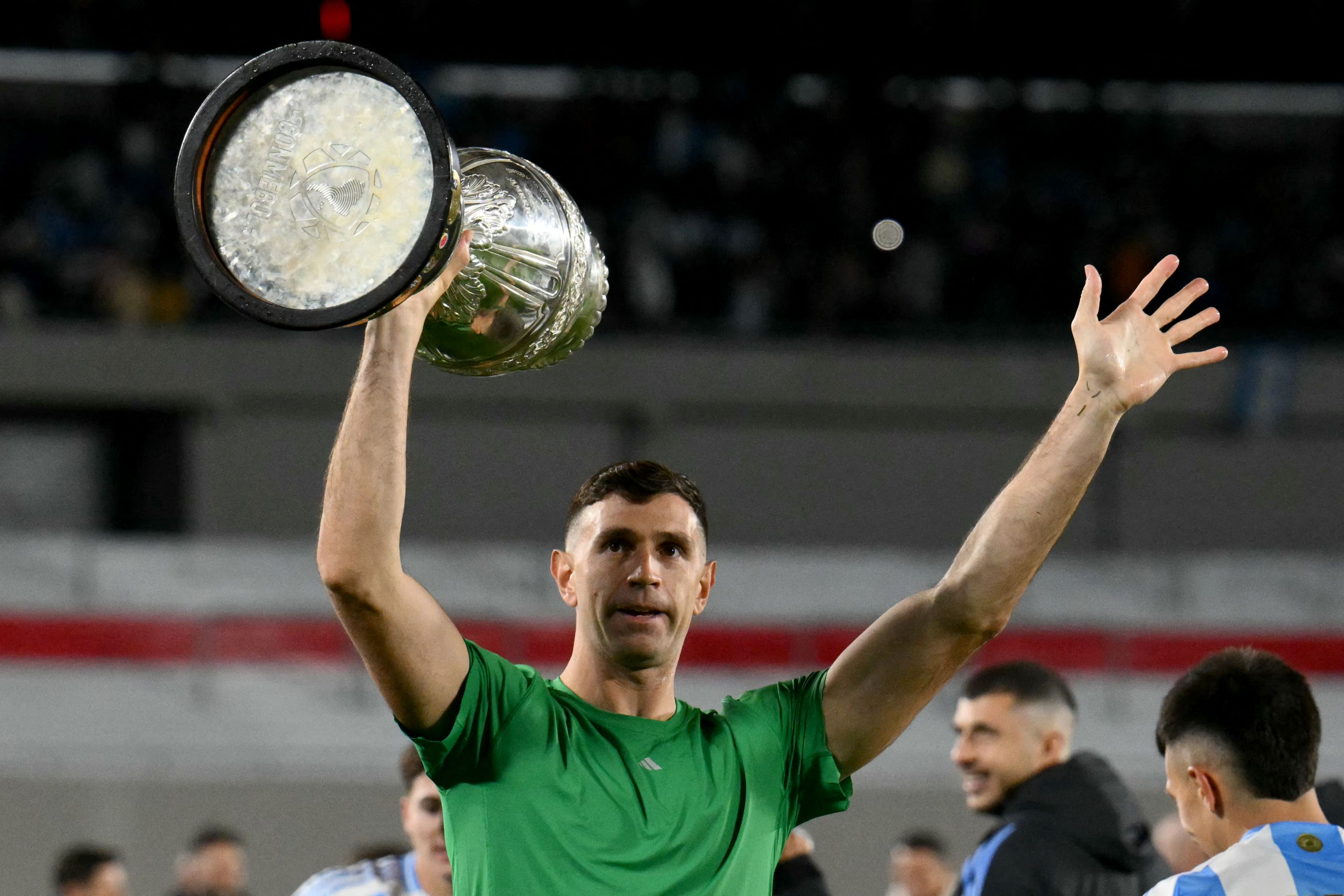 El portero argentino Emiliano Martínez hace un gesto mientras celebra con una réplica del trofeo de la Copa América.