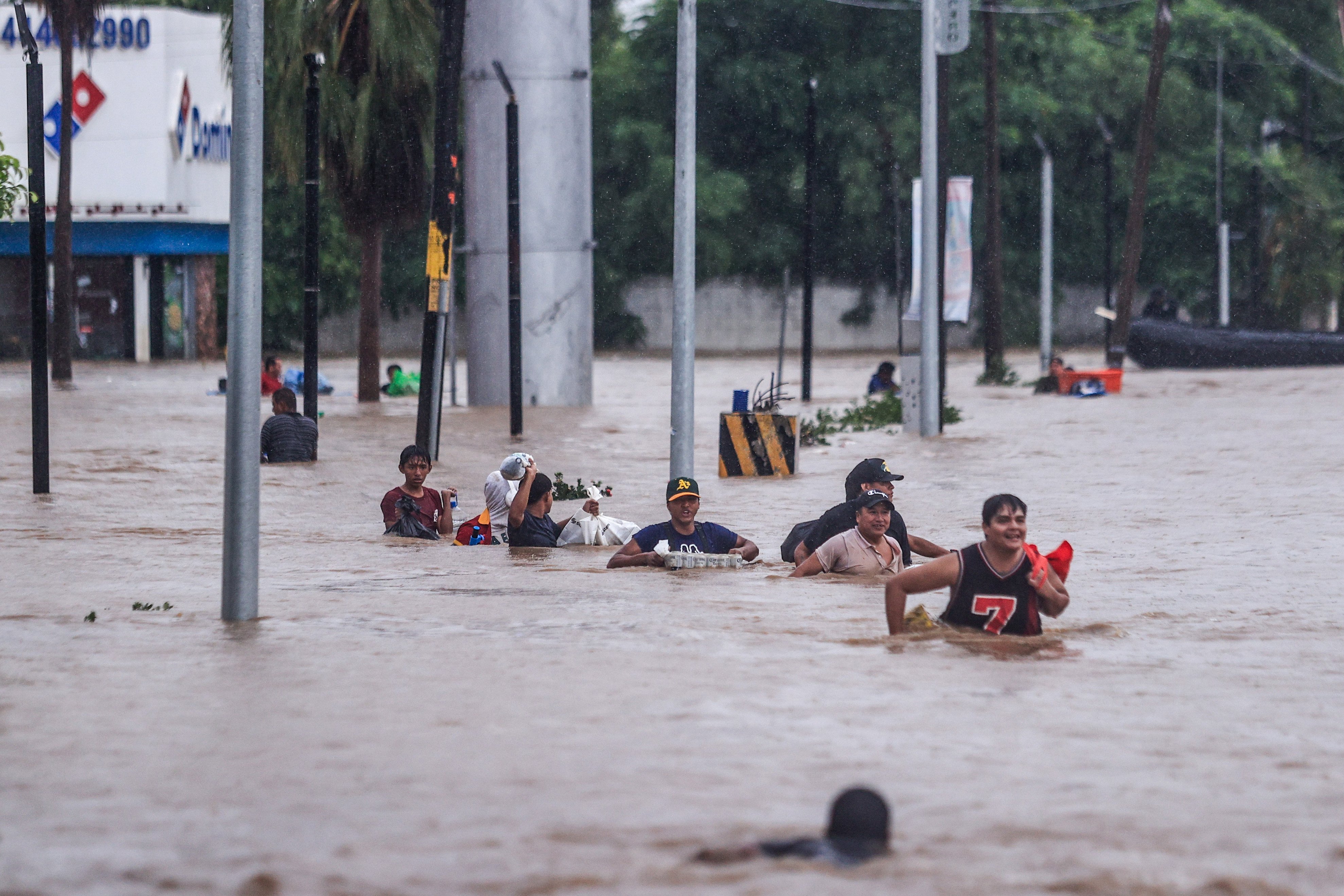 MEX152. ACAPULCO (MÉXICO), 27/09/2024.- Personas cruzan una avenida inundada por el paso del huracán 'John' en la parte alta del puerto de Acapulco, este viernes, en Guerrero (México). Las autoridades mexicanas reportaron este viernes otros 6 muertos por el huracán John, con lo que la cifra de fallecidos aumenta a 22, desde el impacto del ciclón el lunes pasado, de los que 18 son en el estado sureño de Guerrero, otros 3 en el vecino Oaxaca y uno más en Michoacán. EFE/ David Guzmán