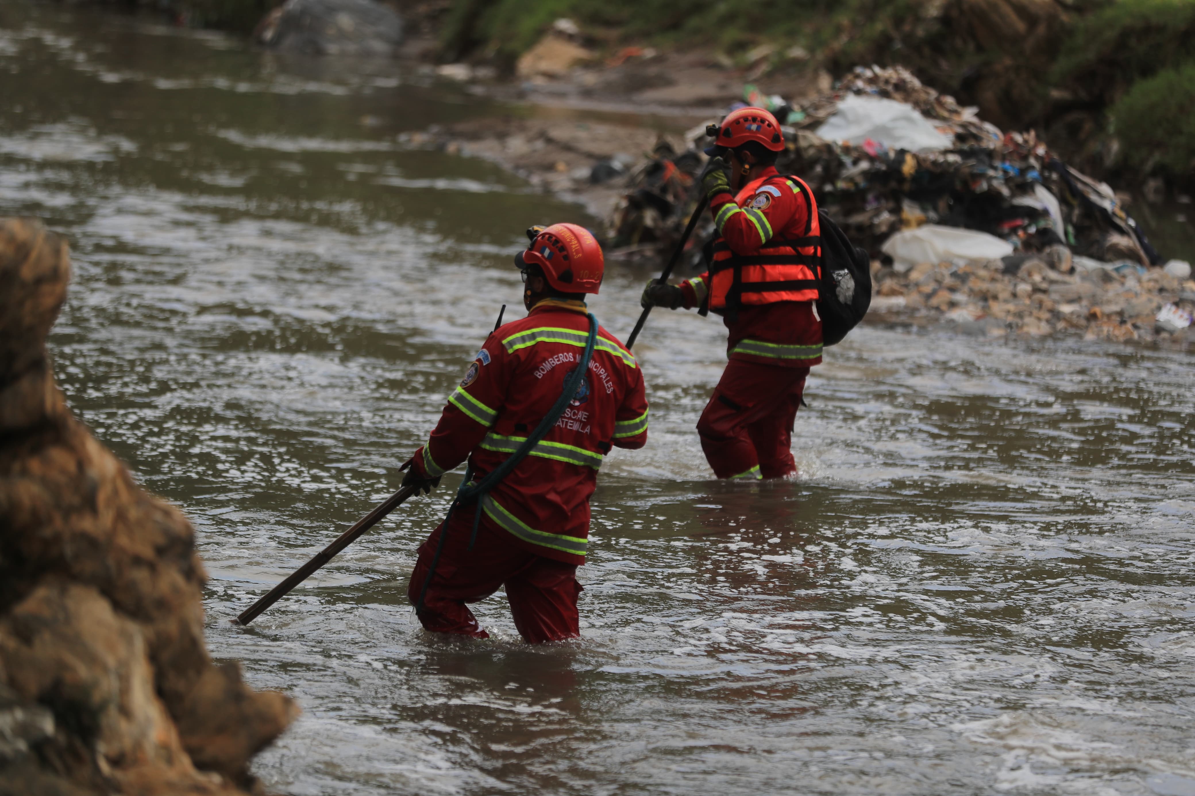 Socorristas recorren la ribera del río Las Vacas en busca de un menor que fue arrastrado por la corriente. (Foto Prensa Libre: Óscar Vásquez)