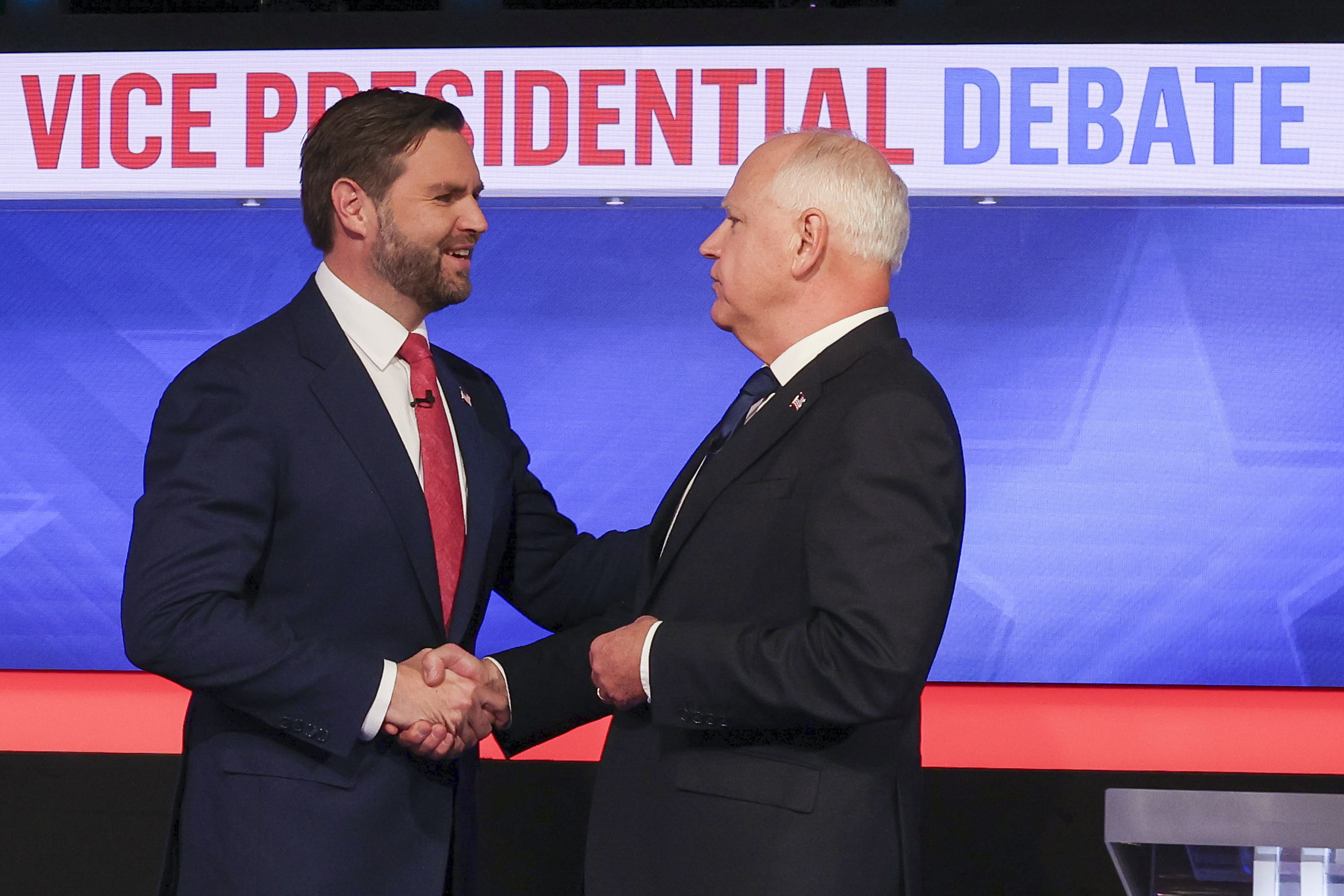 JD Vance (izquierda) y Tim Walz (derecha) saludándose previo al debate televisado de los vicepresidenciables.