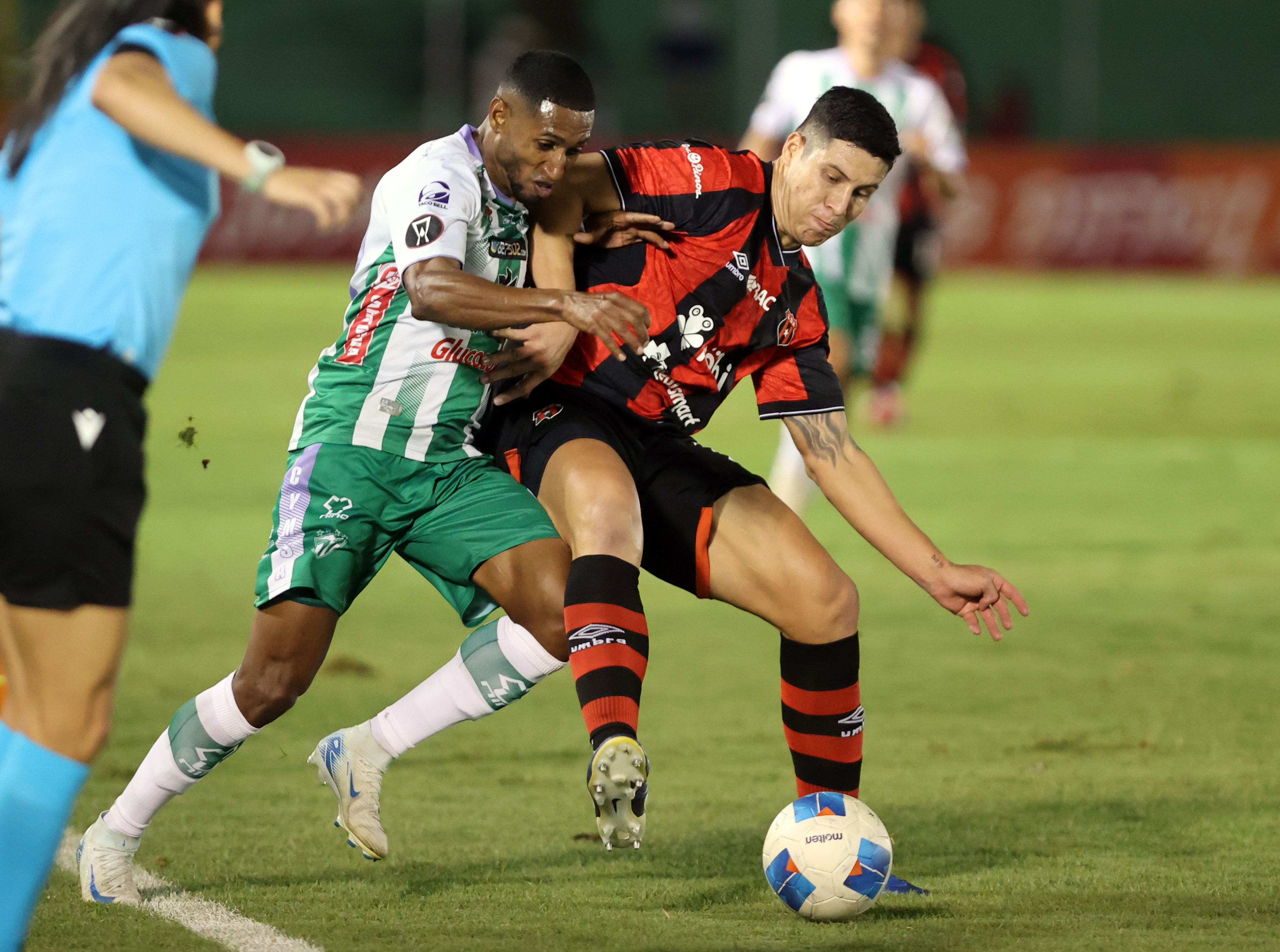 Alexis Gamboa de Liga Deportiva Alajuelense disputa el balón con Romário da Silva de Antigua GFC durante un partido la Copa Centroamericana.