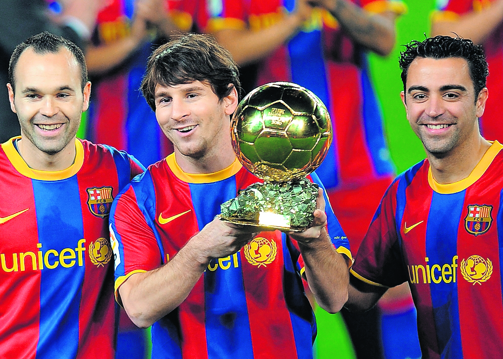 El delantero argentino Lionel Messi junto a Xavi Hernández y Andrés Iniesta con el Balón de Oro 2010.