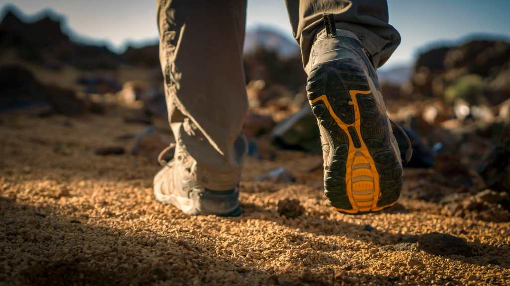 Hombre caminando sobre terreno de tierra. 