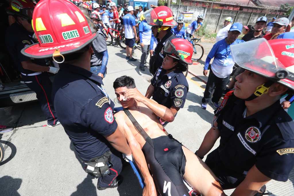 Un ciclista es atendido por bomberos luego de sufrir una caída en la Vuelta a Guatemala. 