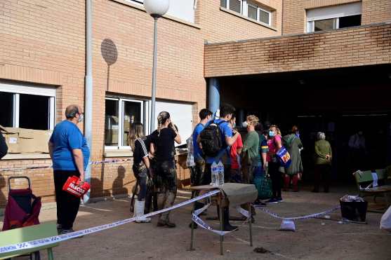 People queue for food distribution in Sedavi, south of Valencia, eastern Spain, on November 5, 2024, following devastating flooding. Spain announced an aid package worth 10.6 billion euros ($11.5 billion) to rebuild regions devastated by its worst floods in a generation that have killed 219 people. (Photo by JOSE JORDAN / AFP)