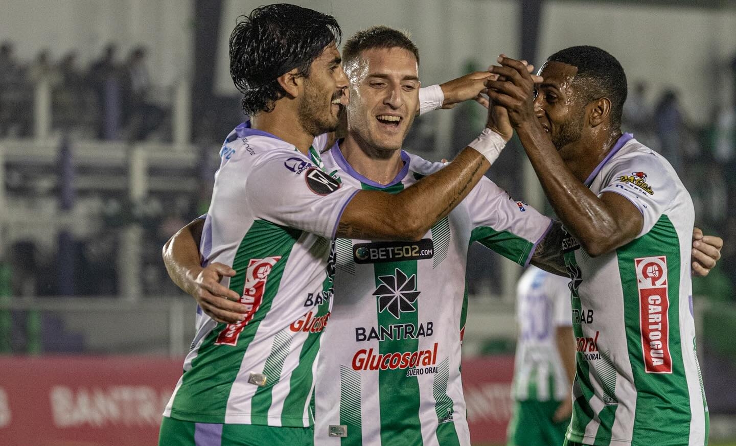 Santiago Gómez celebra un gol junto a Cristian Hernández y Romario Da Silva.