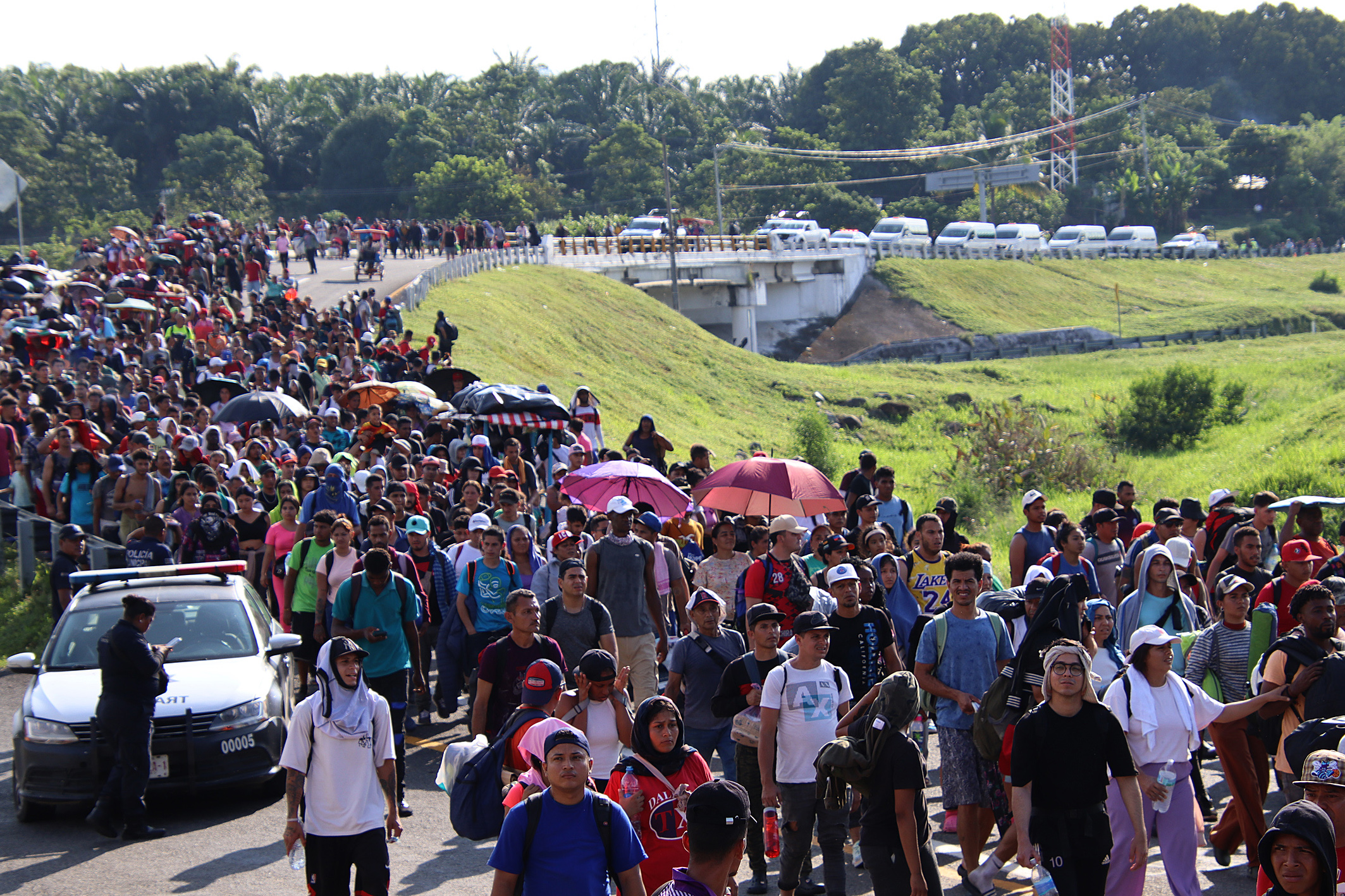 MEX5653. HUIXTLA (MÉXICO), 21/11/2024.- Migrantes caminan en caravana hacia la frontera con Estados Unidos este jueves, en el municipio de Huixtla, en el estado de Chiapas (México). Integrantes de la caravana migrante en el estado de Chiapas, al sur de México, denunciaron este jueves que las autoridades les bloquearon la entrada al municipio de Huixtla, donde pretendían descansar, por lo que urgieron al gobierno de la presidenta Claudia Sheinbaum intervenir para que no se violen sus derechos humanos. EFE/ Juan Manuel Blanco