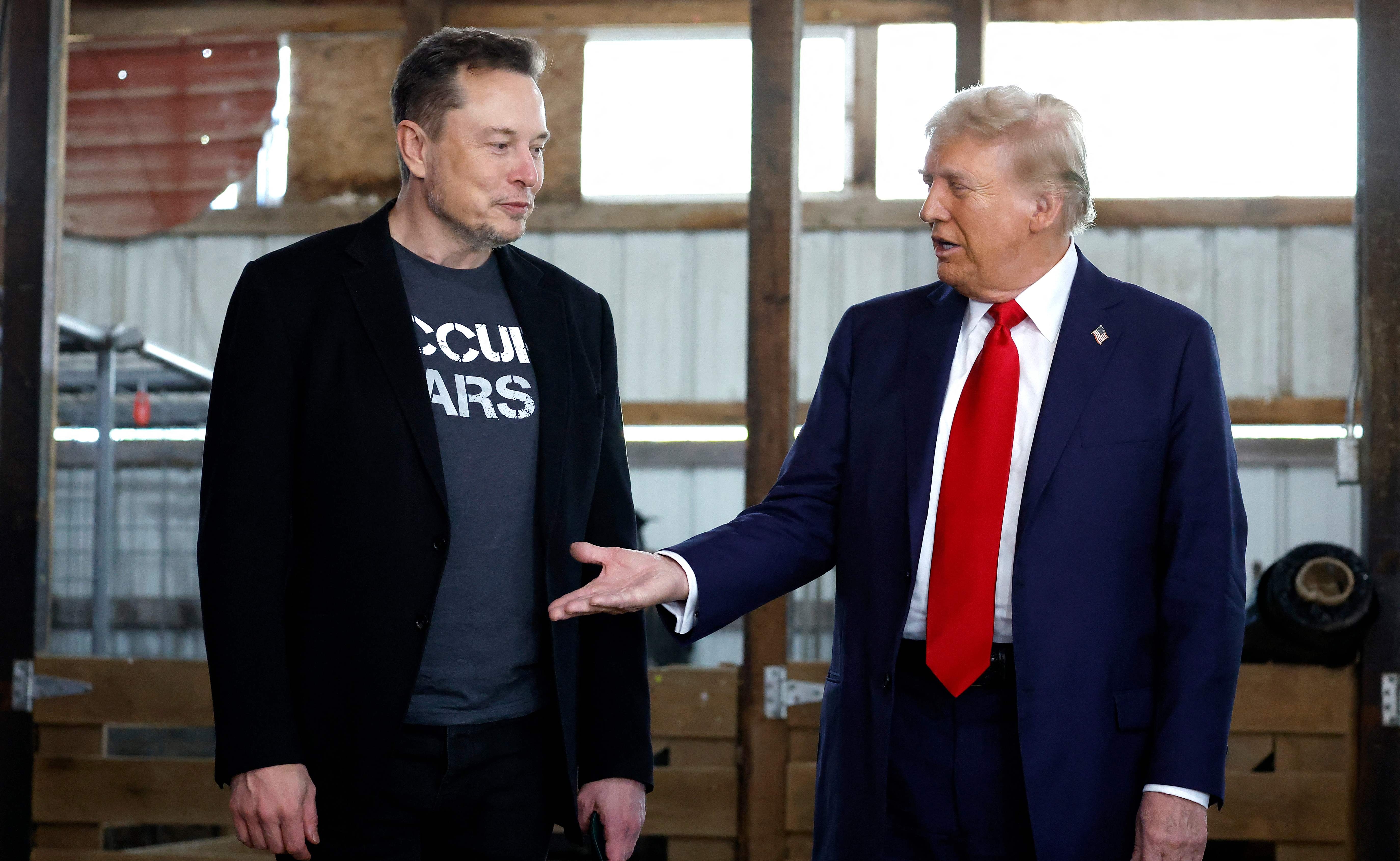 (FILES) Republican presidential nominee, former President Donald Trump offers his hand to Tesla and SpaceX CEO Elon Musk back stage during a campaign rally at the Butler Farm Show grounds on October 05, 2024 in Butler, Pennsylvania. US President-elect Donald Trump on November 12, 2024, said Tesla and SpaceX CEO Elon Musk will lead a so-called Department of Government Efficiency alongside US entrepreneur Vivek Ramaswamy. (Photo by Anna Moneymaker / GETTY IMAGES NORTH AMERICA / AFP)