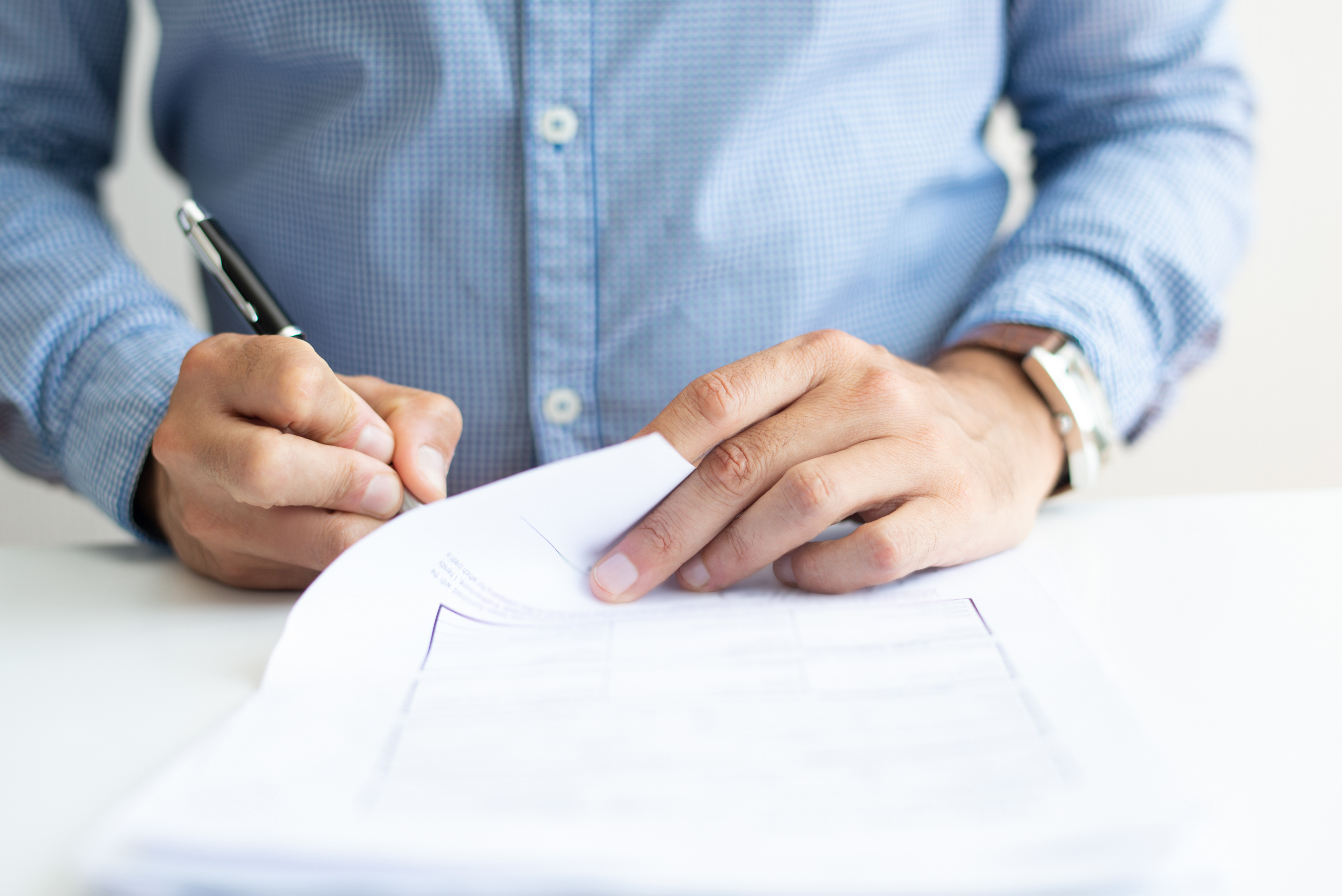 un hombre firmando documentos