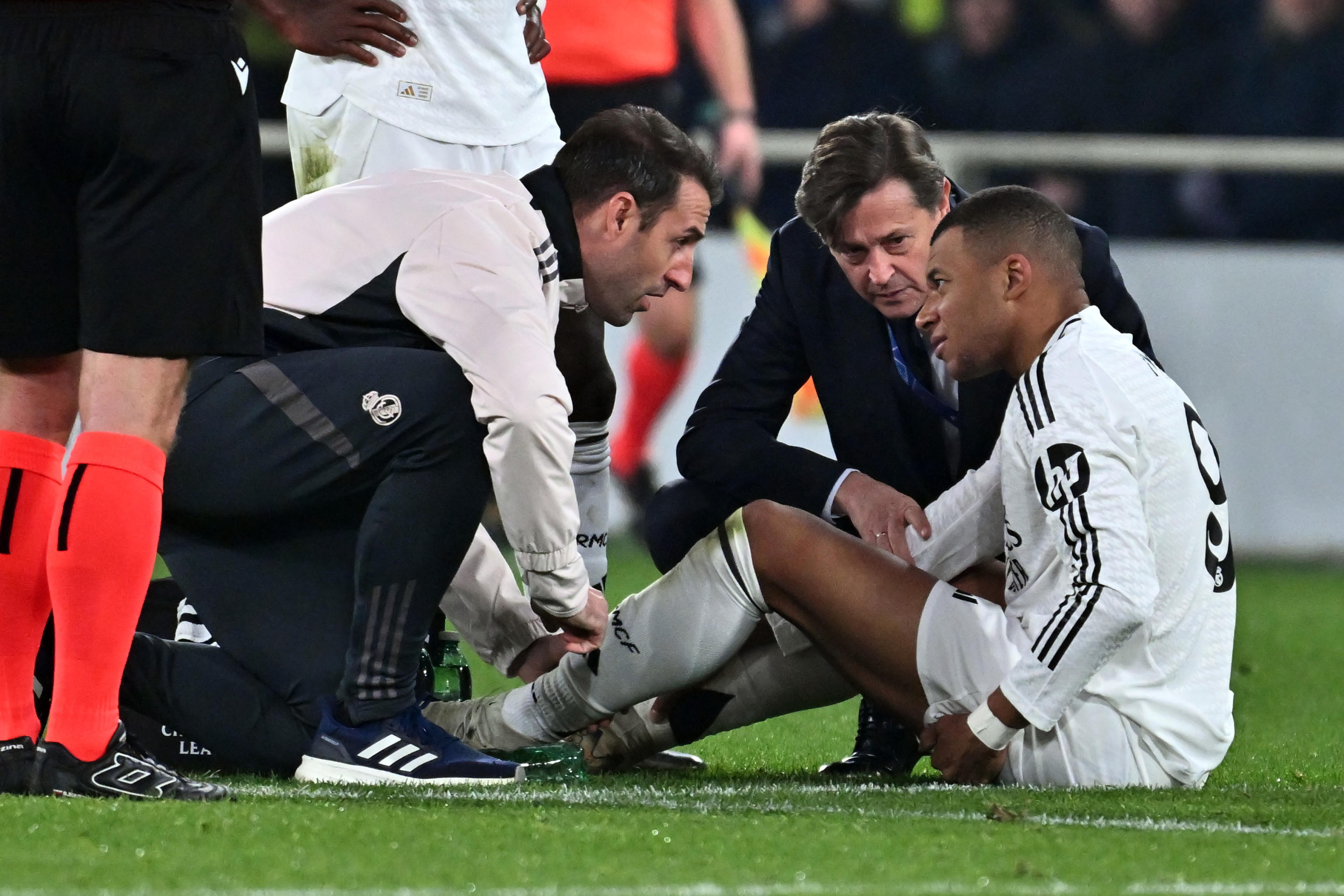 Kylian Mbappé es atendido por los médicos del Real Madrid, tras sufrir una lesión durante el partido contra el Atalanta. (Foto Prensa Libre: EFE).