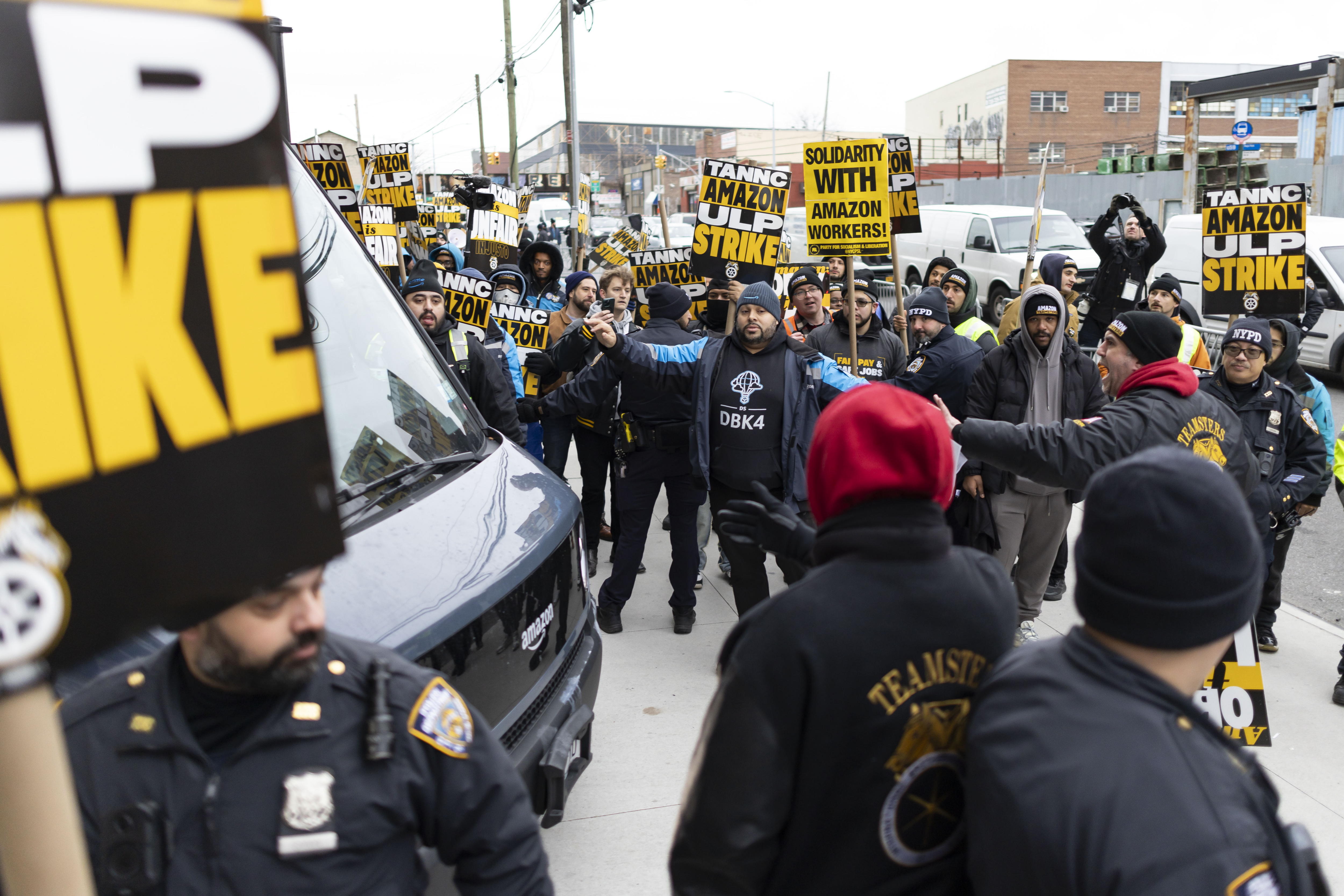 New York (United States), 20/12/2024.- Police officers try to keep a picket line of striking Amazon workers affiliated with the Teamsters union from blocking the exit of an Amazon warehouse in the Queens borough of New York, New York, USA, 20 December 2024. Some unionized Amazon workers began a nationwide strike on 19 December after the company let a union-set deadline for contract negotiations pass last on 15 December. (Nueva York) EFE/EPA/JUSTIN LANE