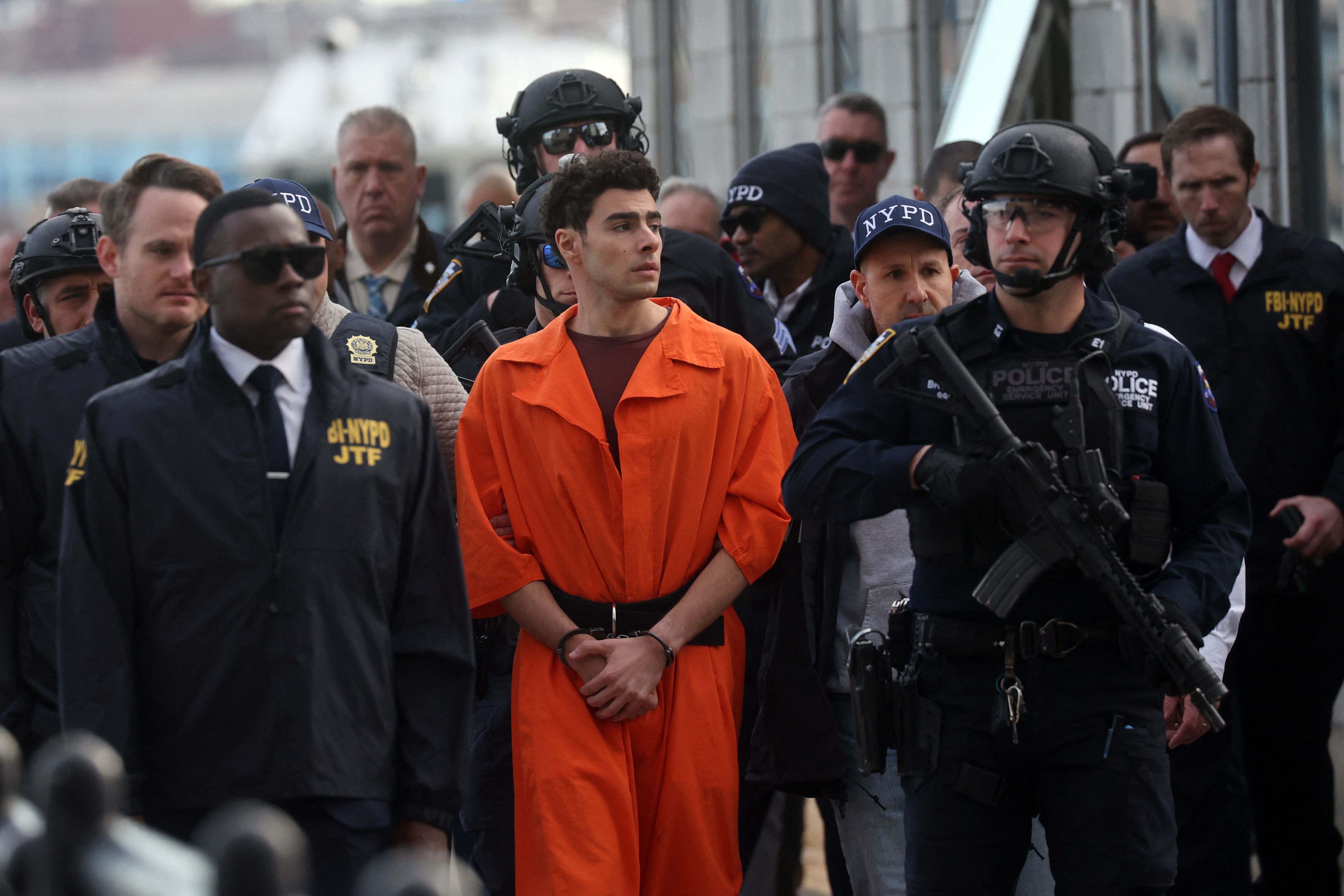 NEW YORK, NEW YORK - DECEMBER 19: Luigi Mangione, suspect in the killing of UnitedHealthcare CEO Brian Thompson in New York City, arrives at a heliport with members of the NYPD on December 19, 2024 in New York City. The 26-year-old was arrested in Pennsylvania on December 9 after being spotted at a McDonald's in Altoona amid a national manhunt. Mangione also appeared in a Pennsylvania court on forgery and firearms charges today, where he waived extradition to New York after being indicted on 11 charges including first-degree murder in furtherance of terrorism. Spencer Platt/Getty Images/AFP (Photo by SPENCER PLATT / GETTY IMAGES NORTH AMERICA / Getty Images via AFP)