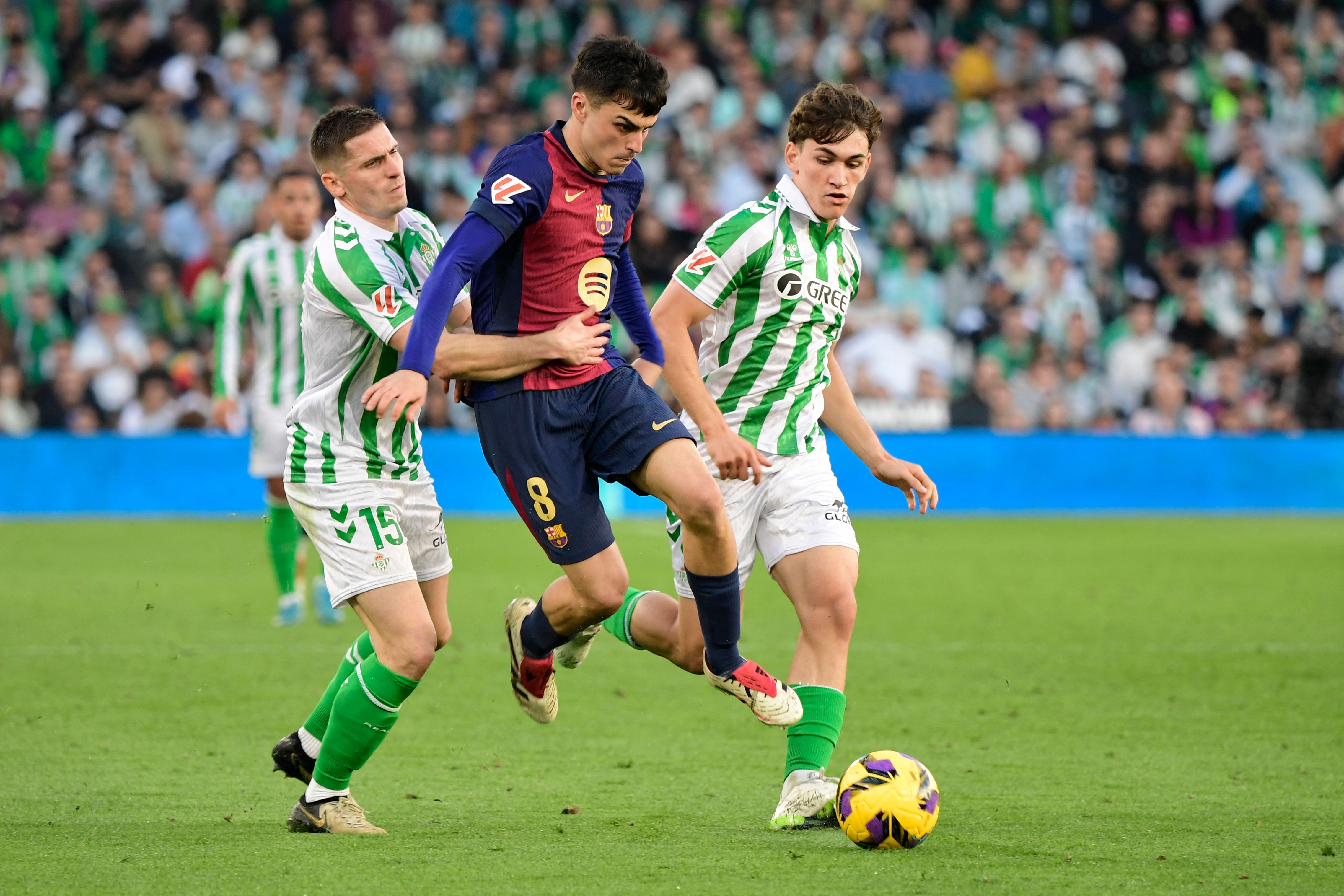 Pedri y Mateo Flores luchan por un balón en un duelo de liga entre Barcelona y Betis.