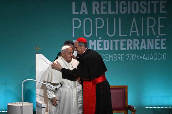 French bishop of Corsica Francois-Xavier Bustillo welcomes Pope francis at the conference "La religiosité populaire en méditerranée" (Popular religiosity in the Mediterranean) in Ajaccio, as part of his trip on the French island of Corsica, on December 15, 2024. Pope Francis visits Corsica, a stronghold of the Catholic faith with locals hotly anticipating the first-ever trip by a pontiff to the French Mediterranean island. His short trip, based around a congress on faith in the Mediterranean region, comes just a week after he snubbed the re-opening of Notre Dame cathedral in Paris five years after a devastating fire. (Photo by Tiziana FABI / AFP)