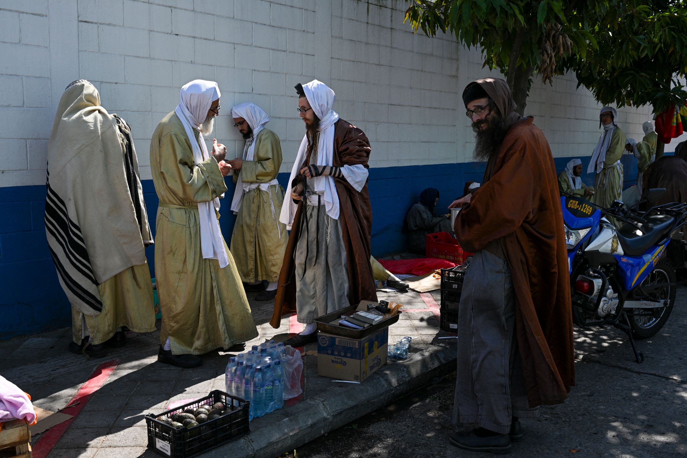 Integrantes de la comunidad Lev Tahor permanecen fuera de un albergue donde fueron trasladados menores rescatados por autoridades, luego de un allanamiento registrado en diciembre de 2024. (Foto Prensa Libre: AFP)