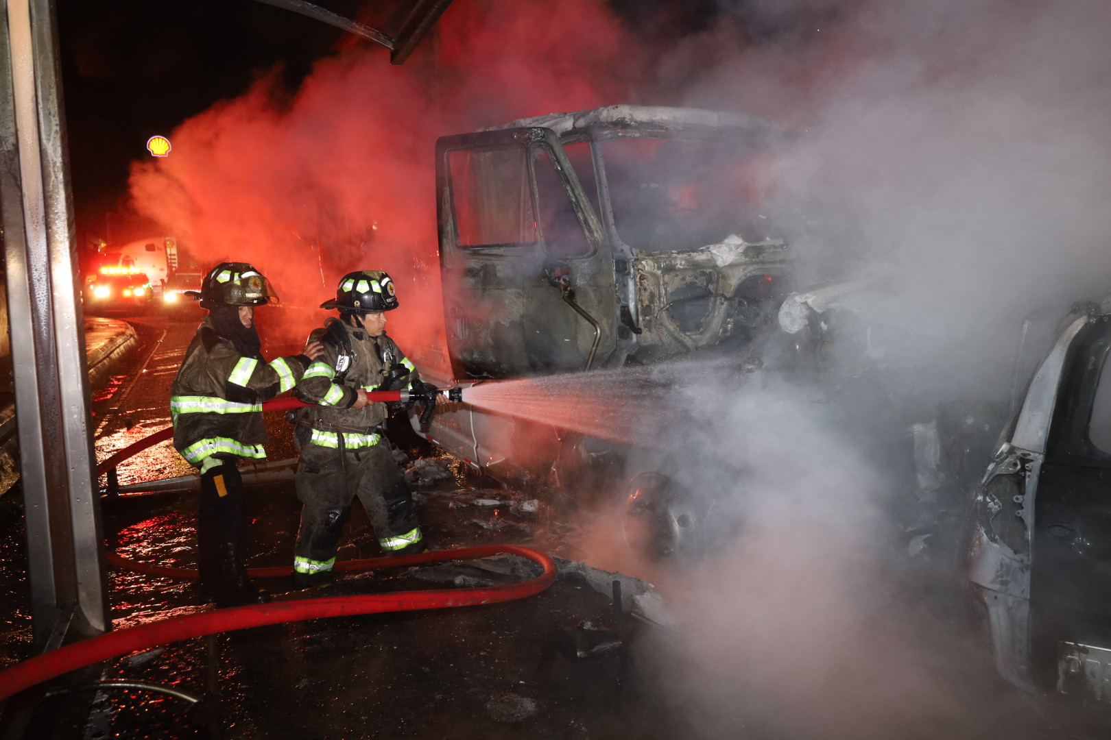 Bomberos sofocan el fuego en un vehículo que se incendió luego de chocar con un camión en ruta a El Salvador. (Foto Prensa Libre: Bomberos Voluntarios)